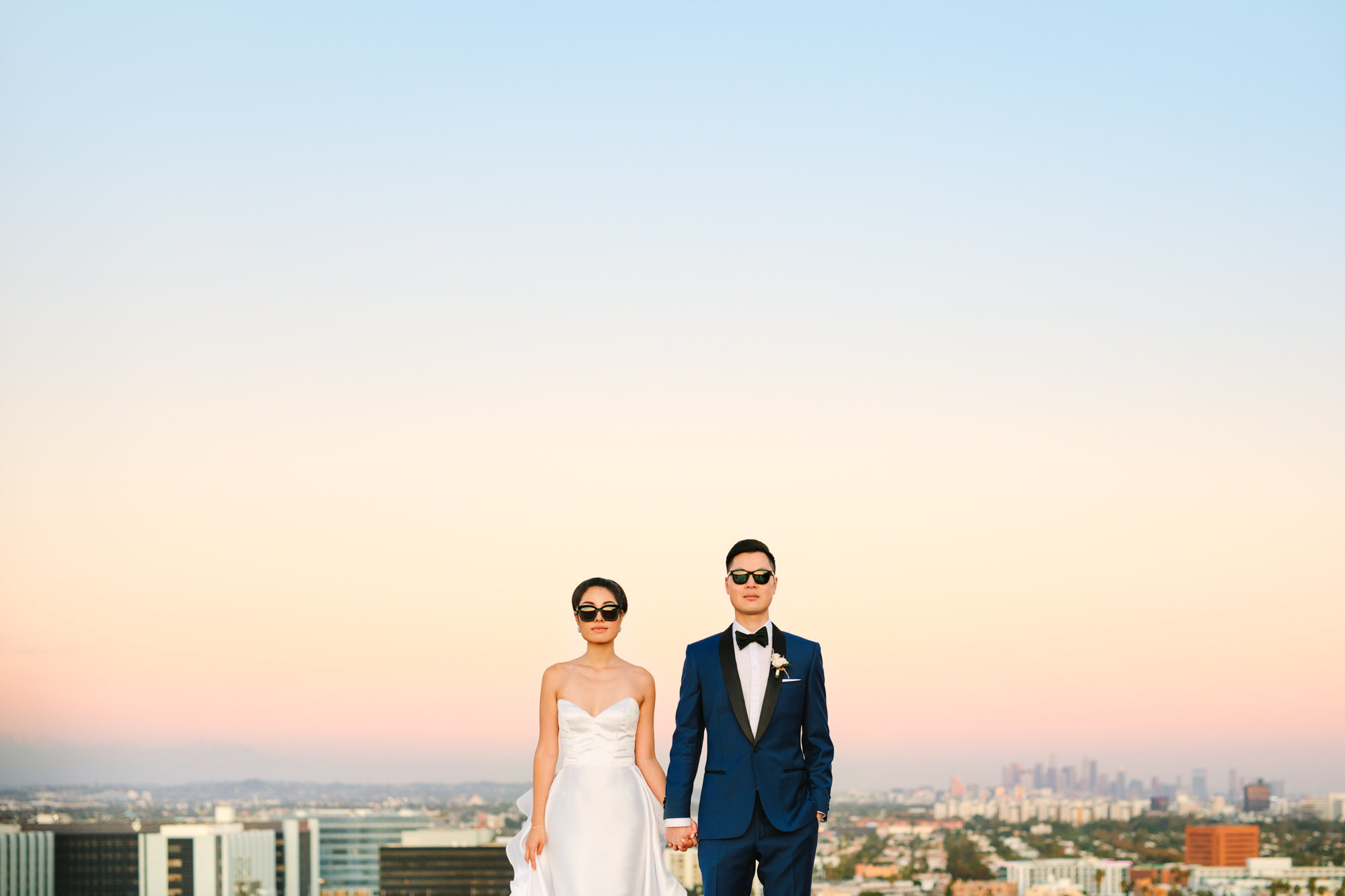 Bride and groom in sunglasses with Los Angeles skyline Indian Fusion wedding at Fig House Los Angeles by Mary Costa Photography