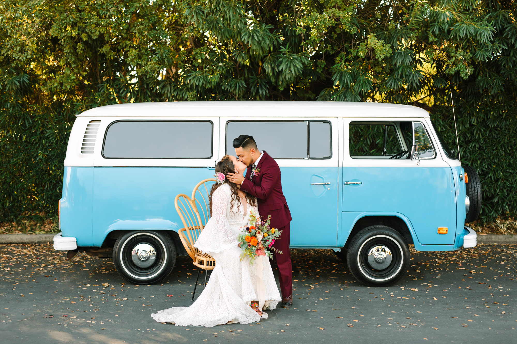 Bride and groom kissing with VW Van by Mary Costa Photography