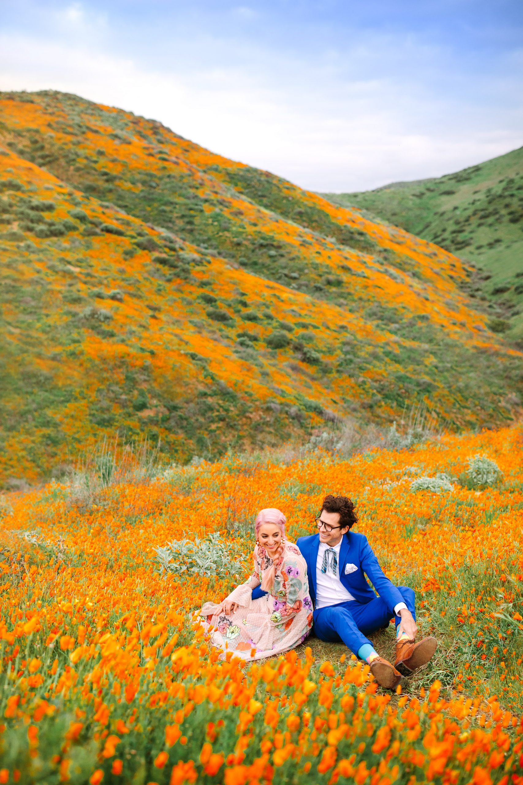 Couple in poppy field by Mary Costa Photography