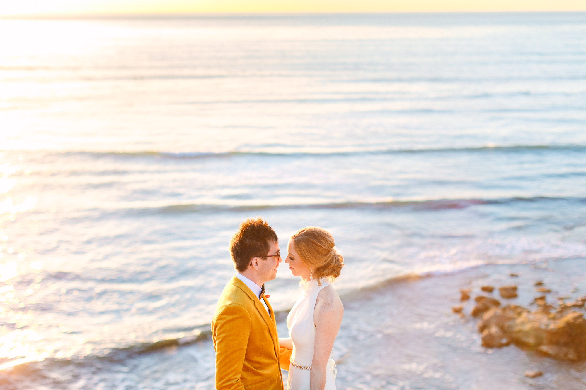 Wedding couple at the ocean during sunset by Mary Costa Photography