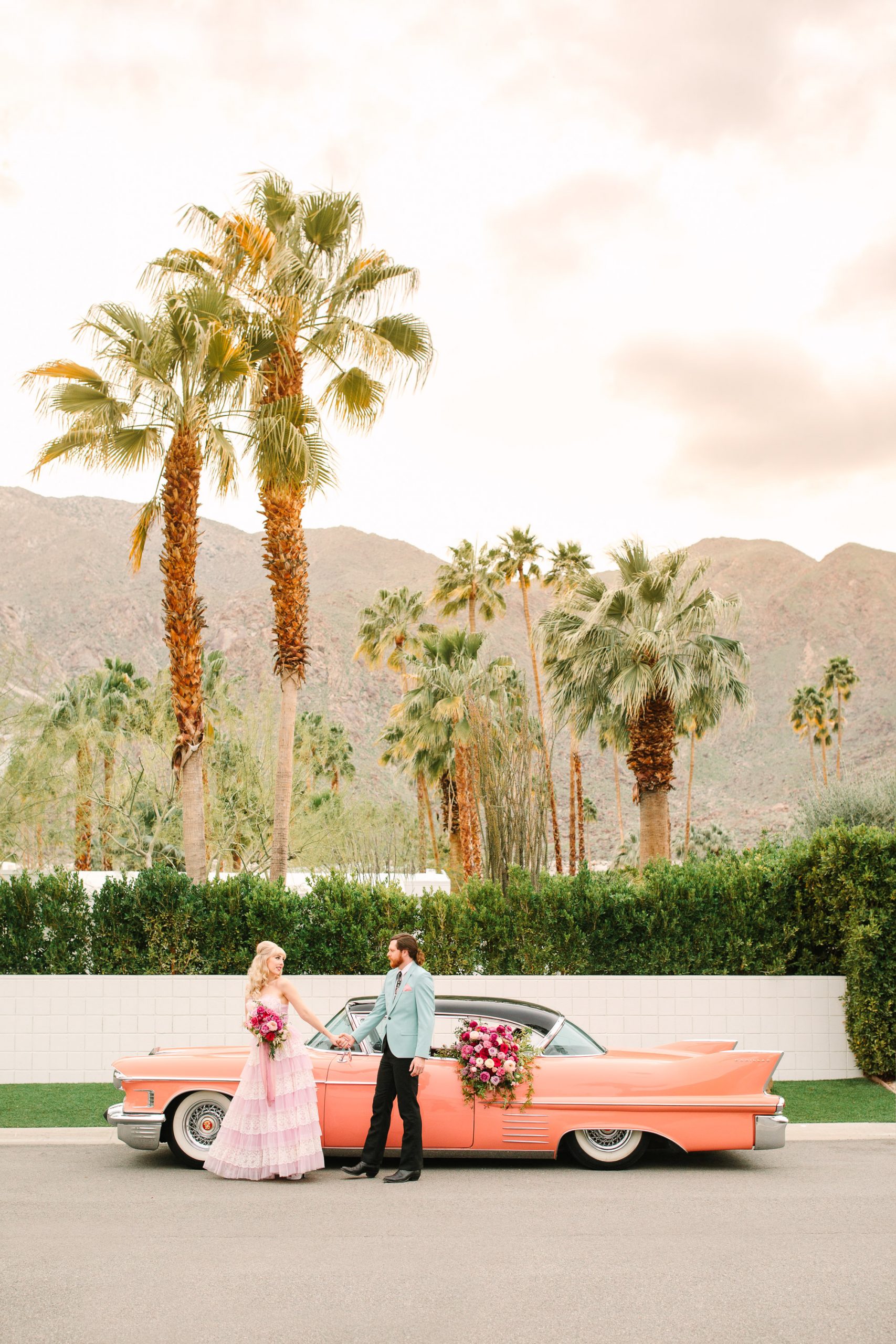 Couple with vintage pink Cadillac by Mary Costa Photography