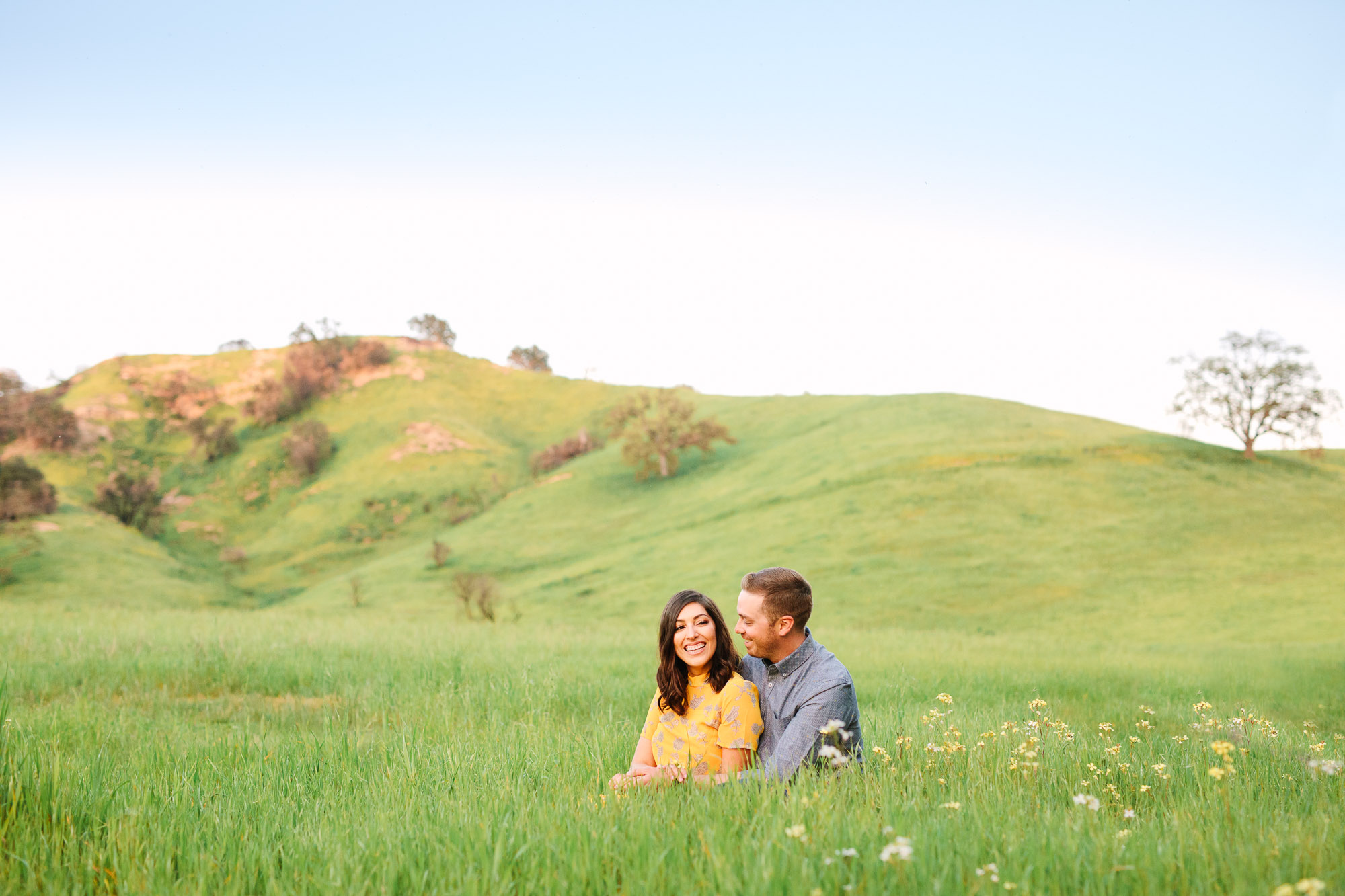 Couple in green rolling field by Mary Costa Photography