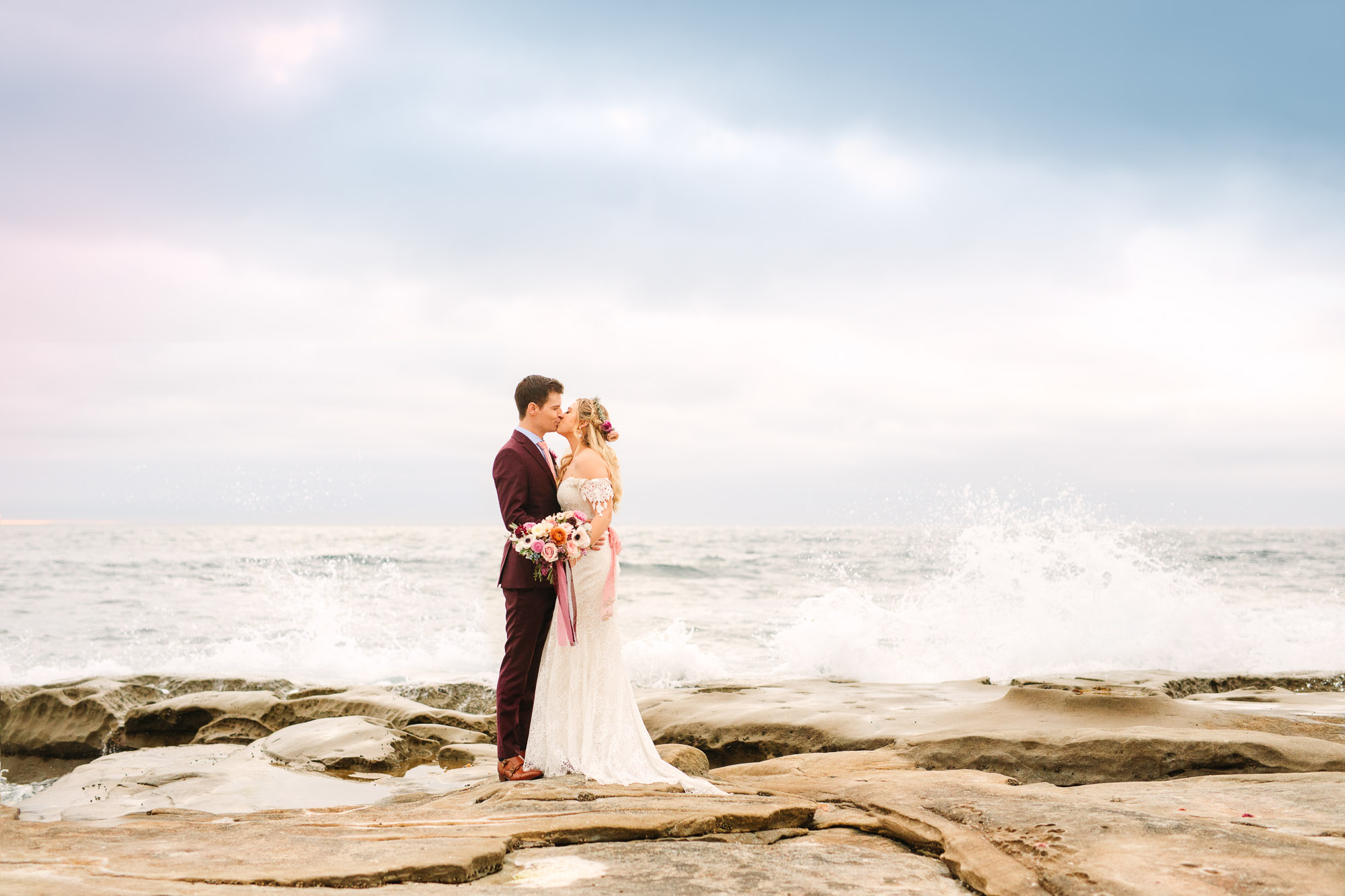Wedding couple kissing at La Jolla beach by Mary Costa Photography