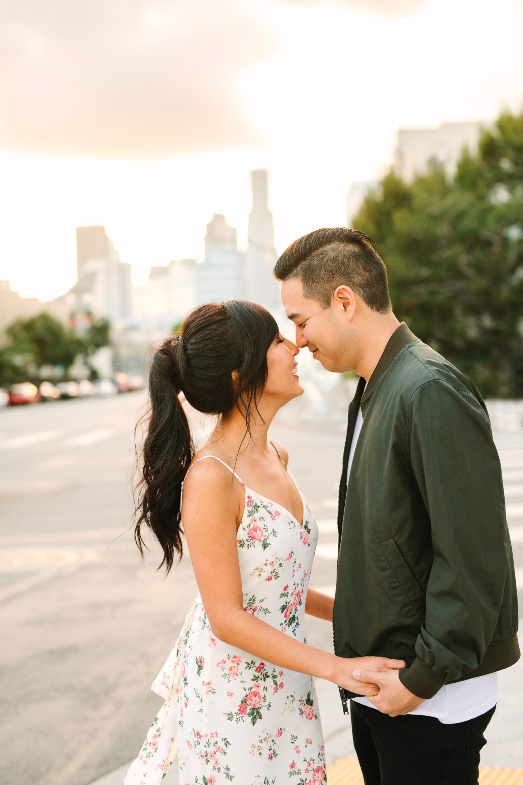 Couple snuggling with LA skyline behind them by Mary Costa Photography
