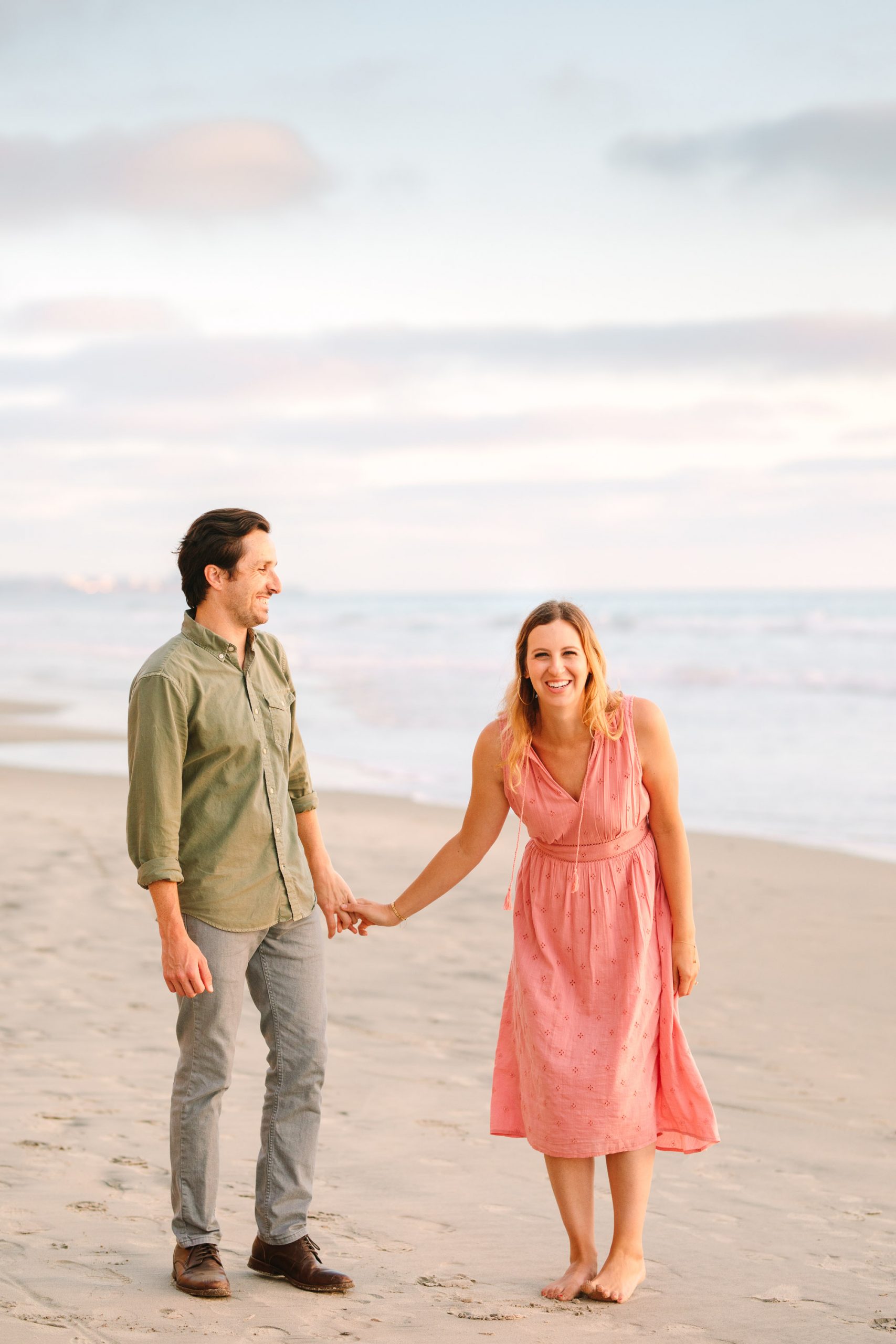 Couple laughing on beach for engagement session by Mary Costa Photography