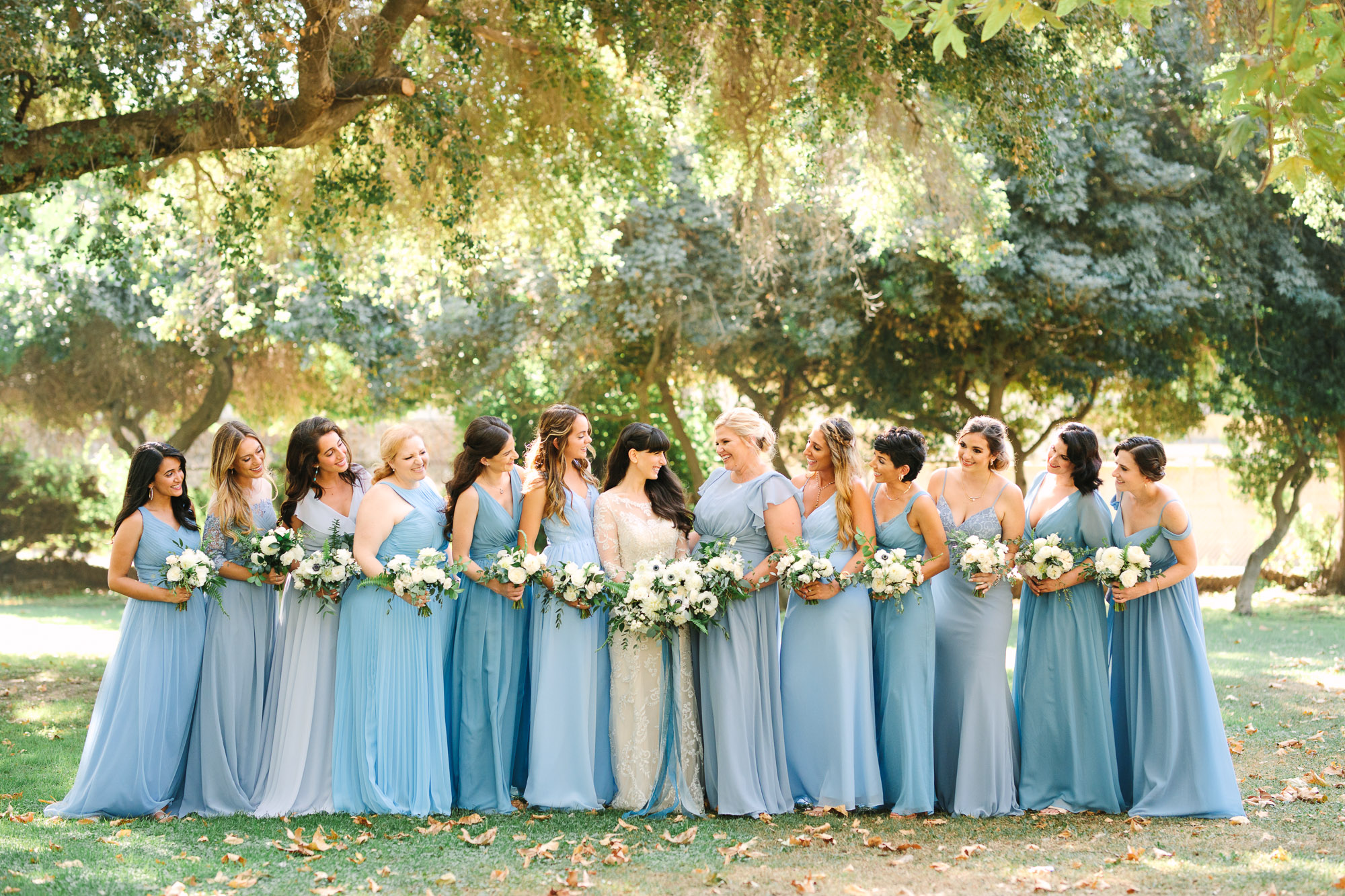 Bridesmaids in mismatched blue dresses by Mary Costa Photography