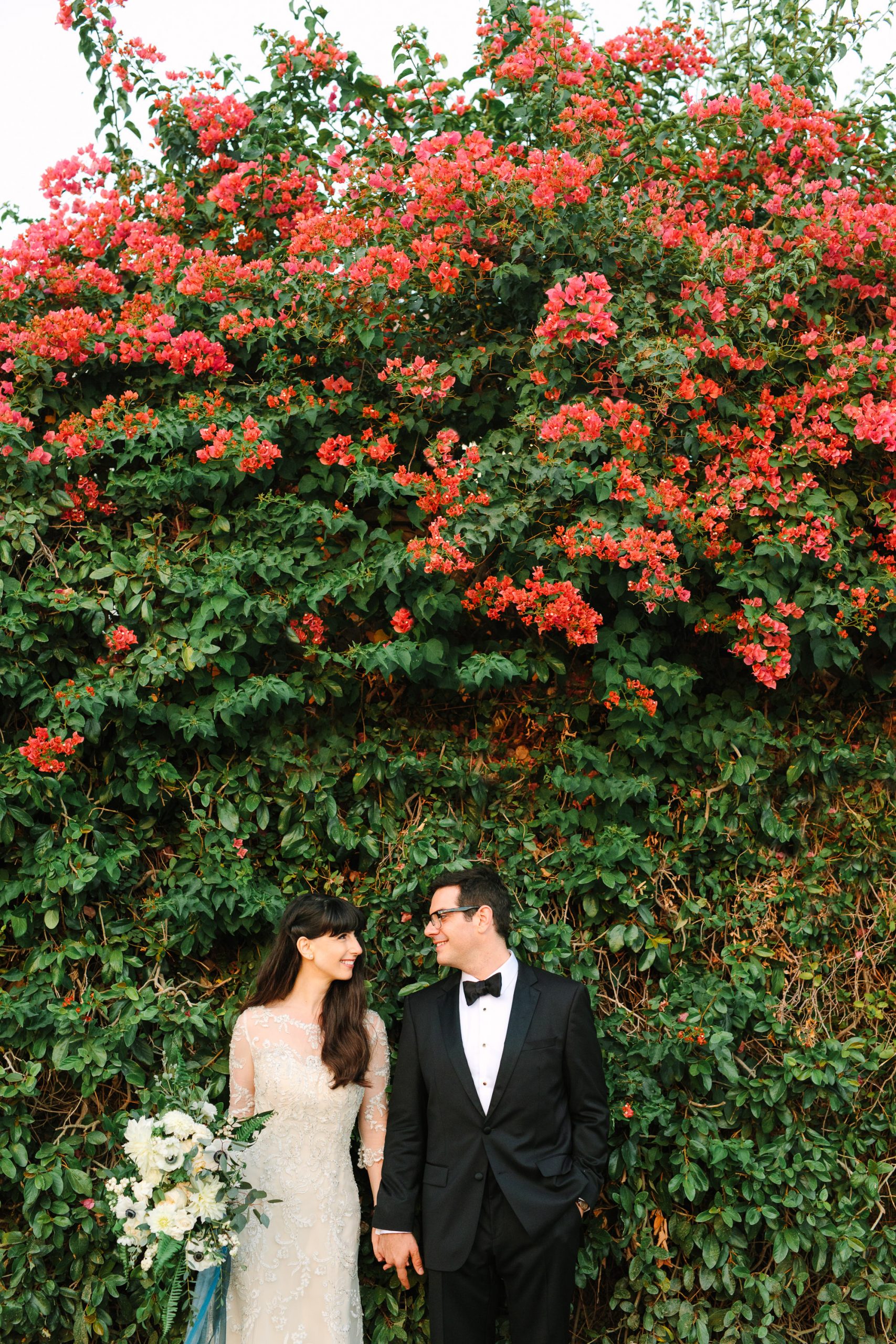 Bride and groom portrait with bougainvillea by Mary Costa Photography