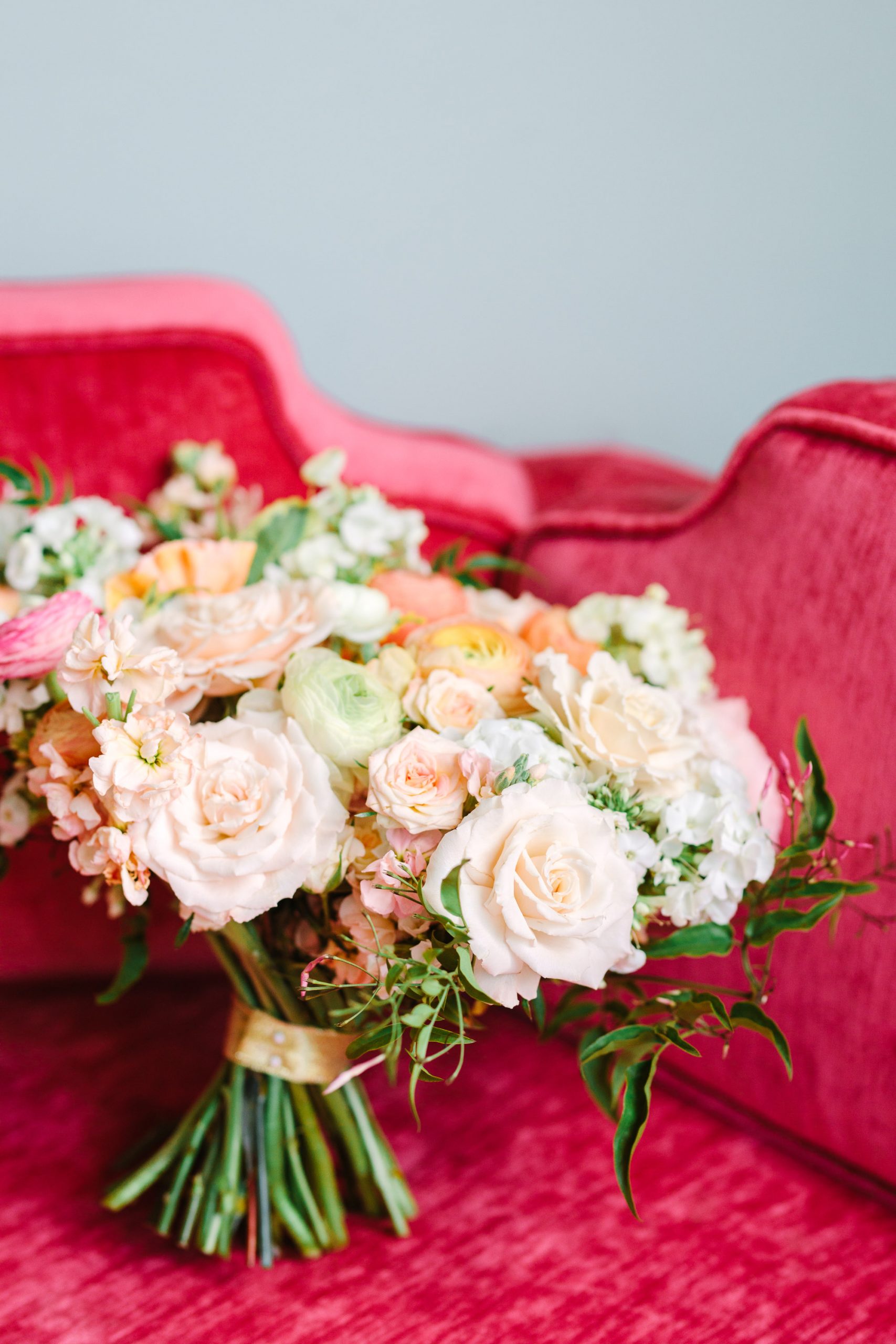 Bridal bouquet on pink couch by Mary Costa Photography