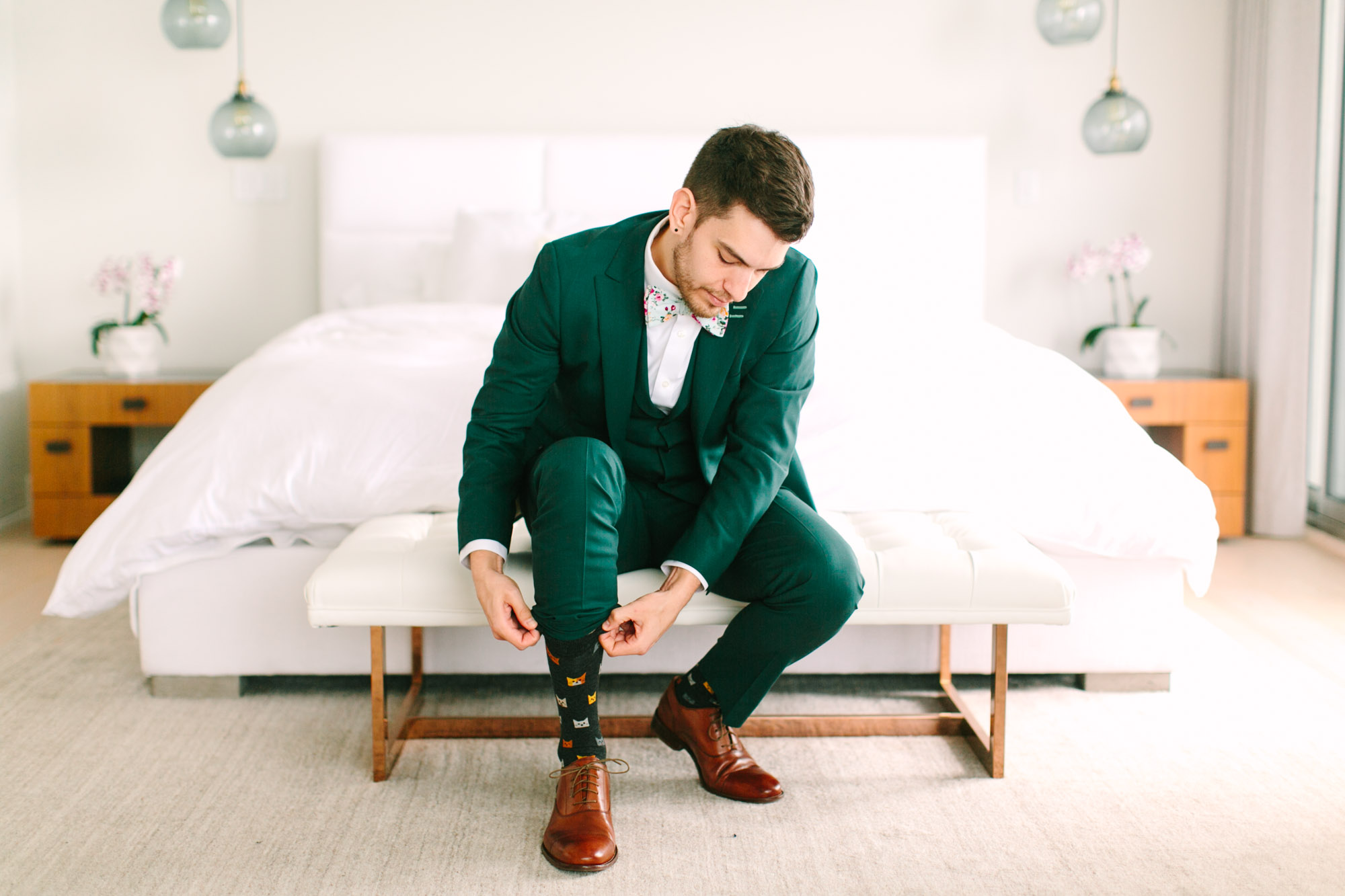Groom getting ready in emerald tux by Mary Costa Photography