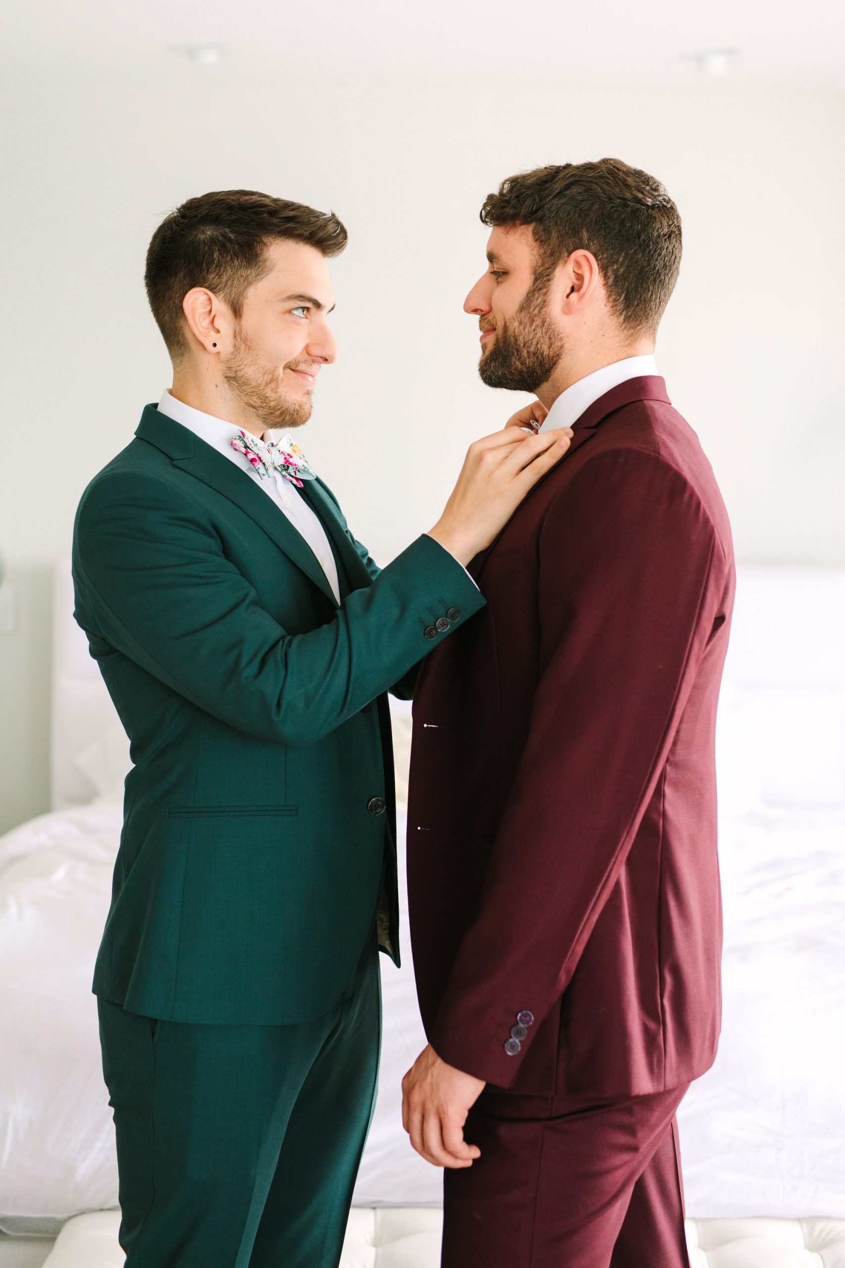 Two grooms getting ready by Groom getting ready in emerald tux by Mary Costa Photography