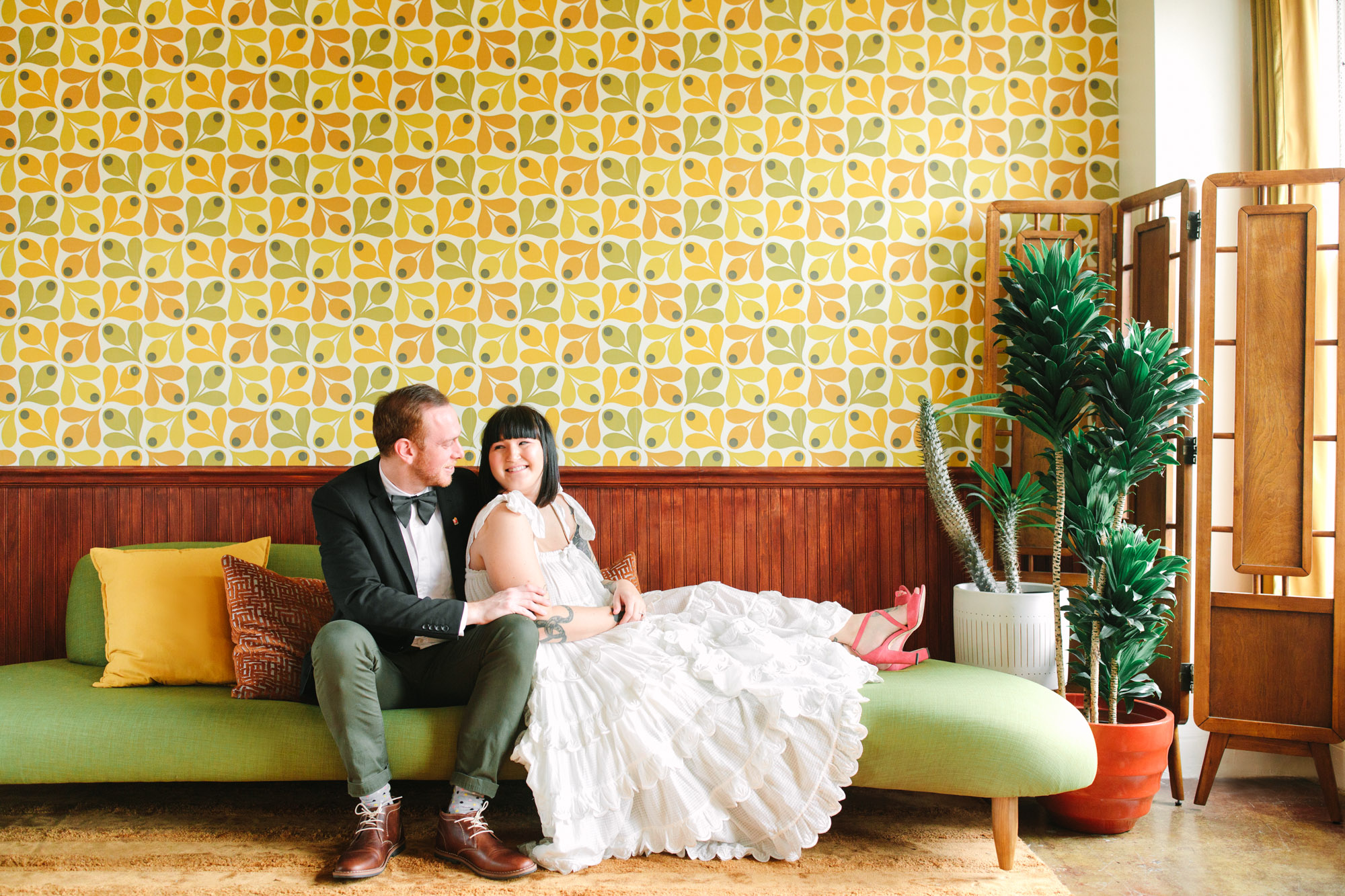 CouCouple on Mid Century Modern couch in retro room www.marycostaweddings.com