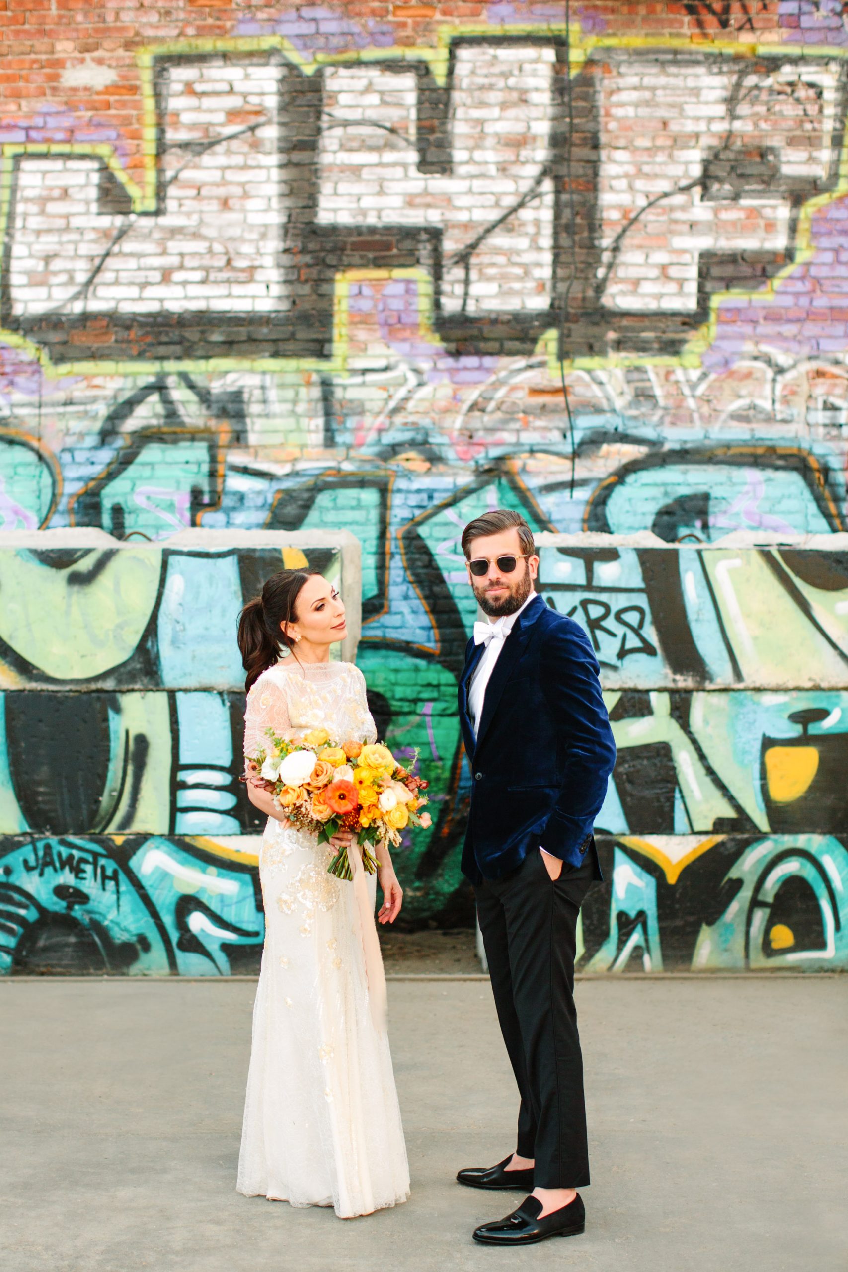 Bride and groom first look with graffiti backdrop www.marycostaweddings.com