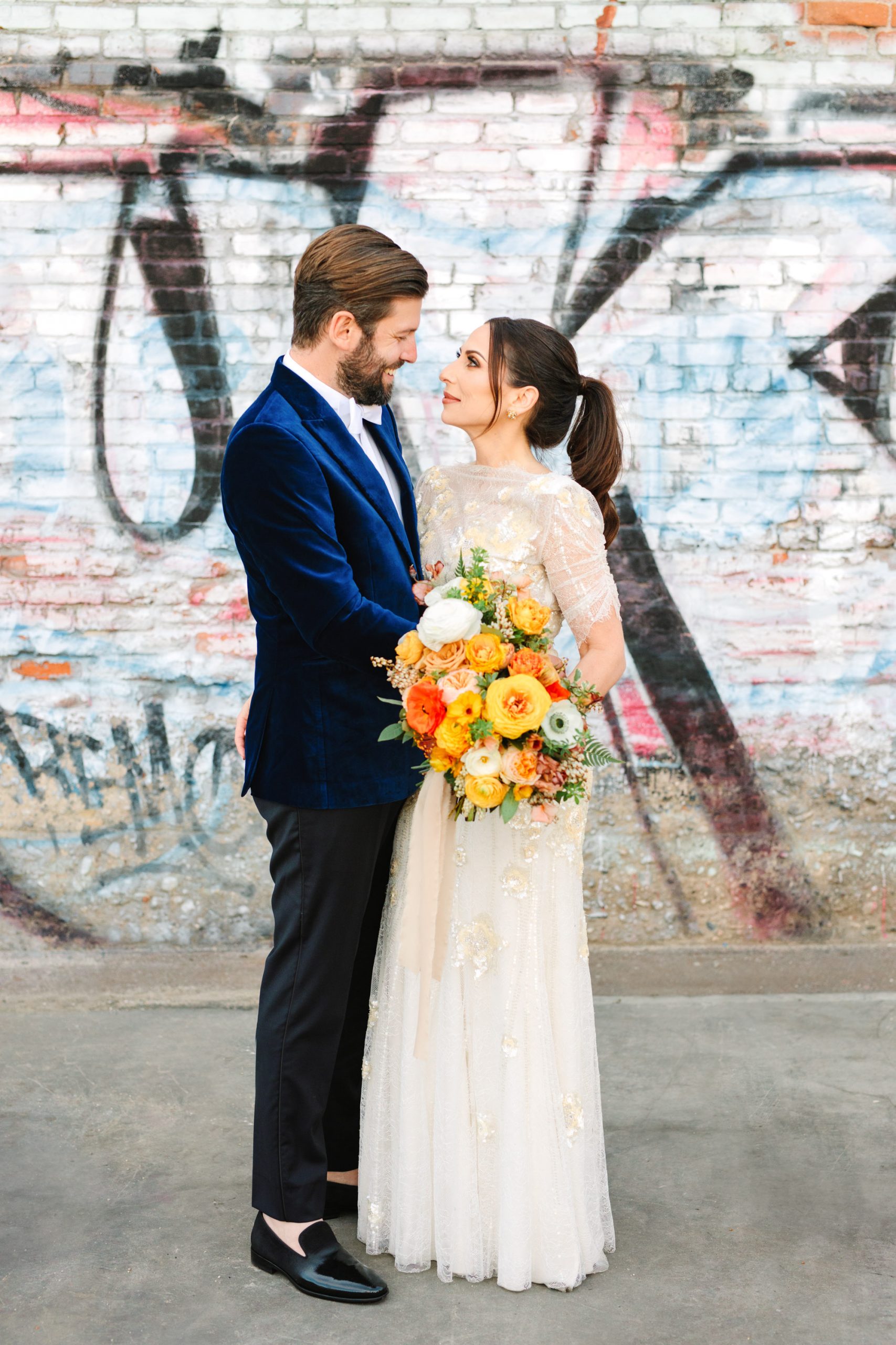 Bride and groom with graffiti backdrop in Los Angeles Arts District www.marycostaweddings.com