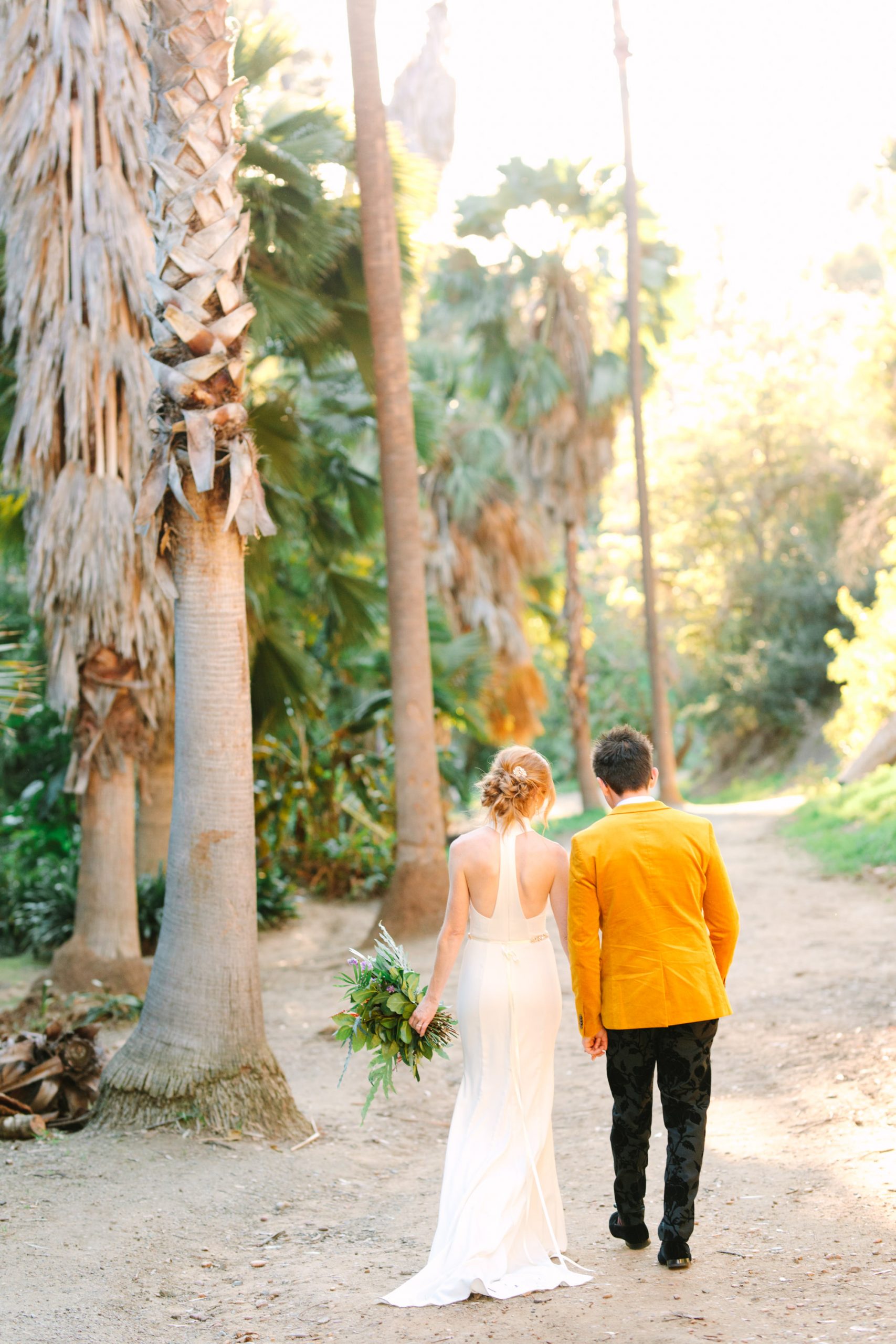 Bride and groom walking among palm trees - www.marycostaweddings.com