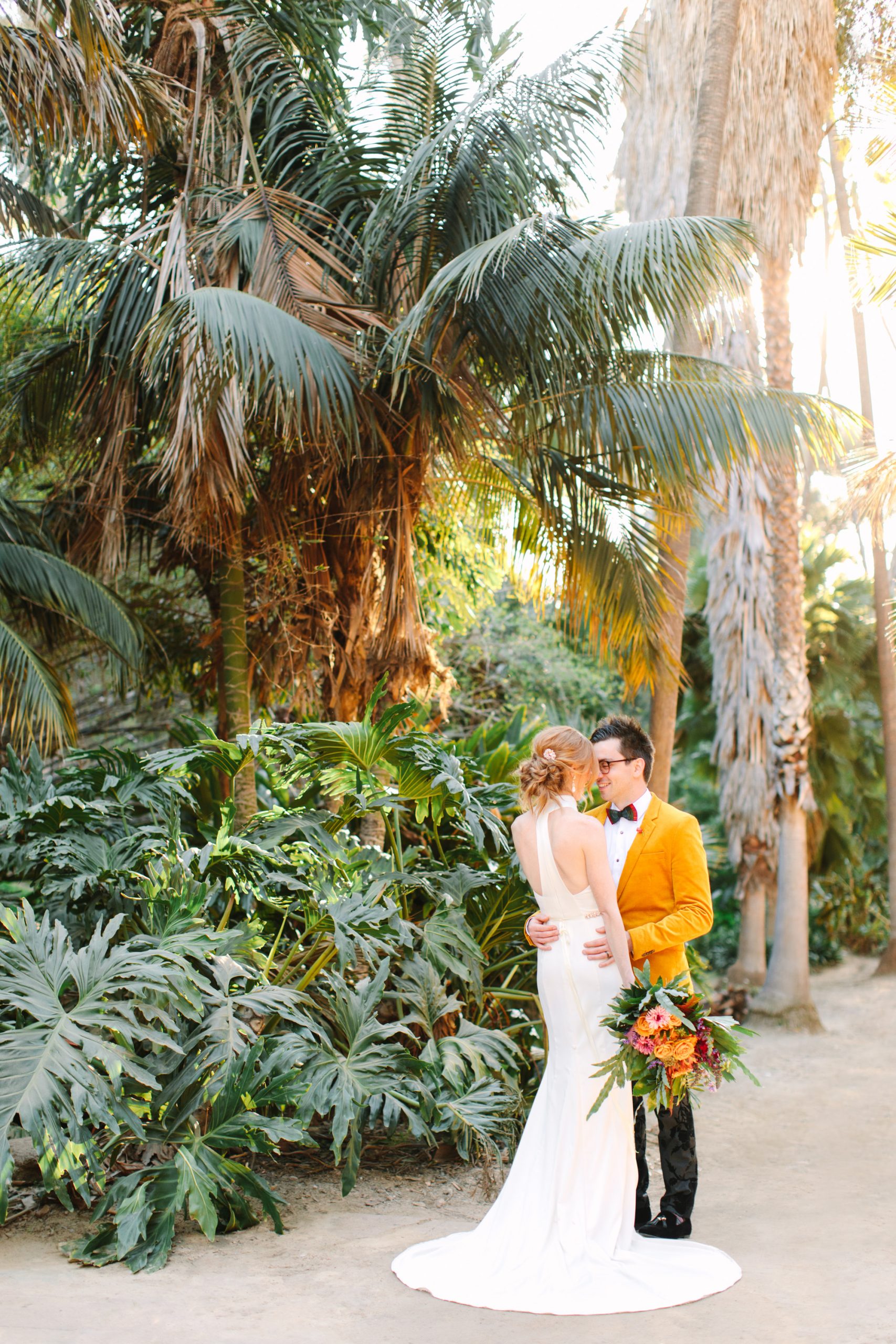 Couple embracing in palm garden - www.marycostaweddings.com