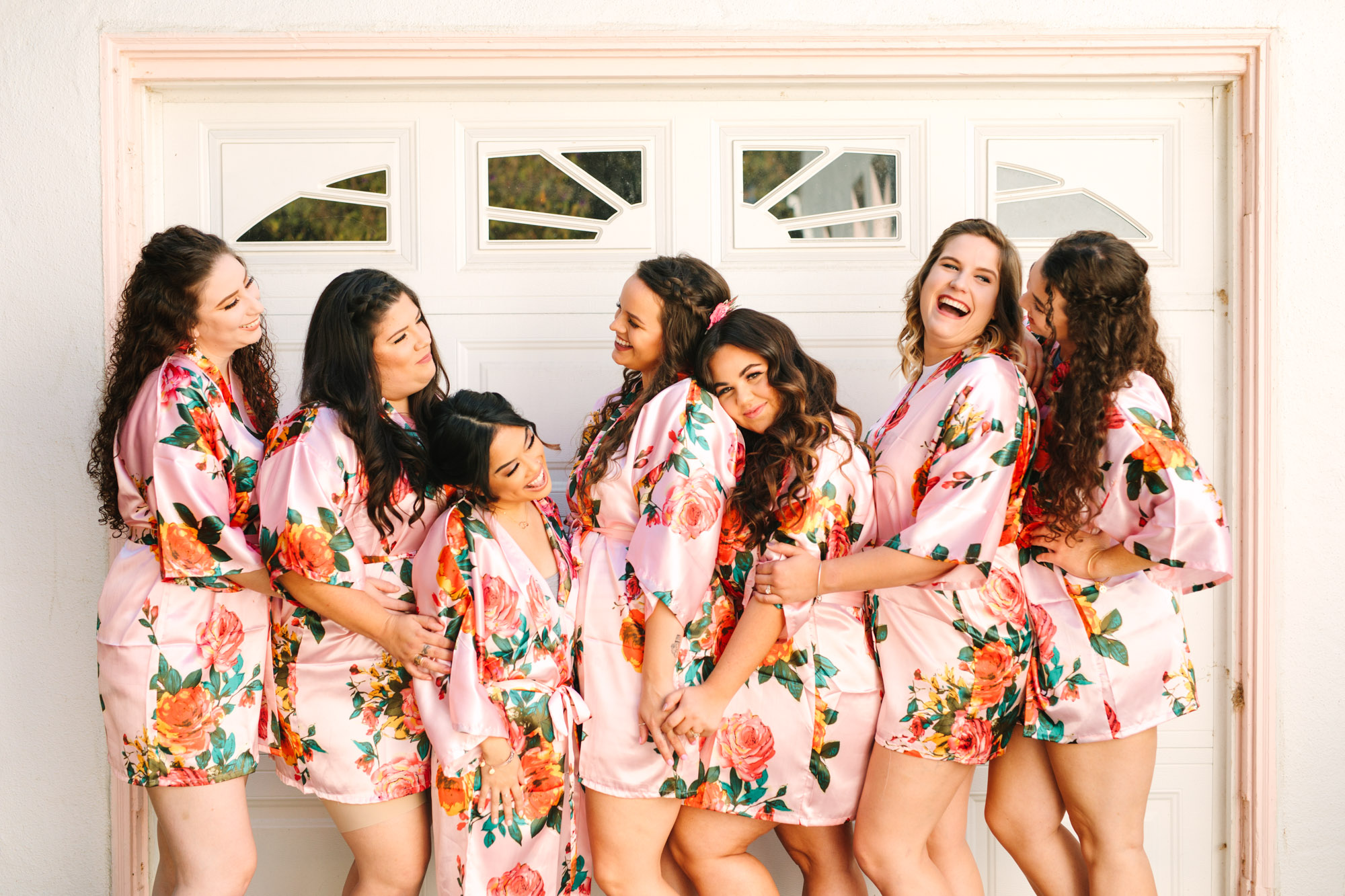 Bridesmaids in pink floral satin robes - www.marycostaweddings.com