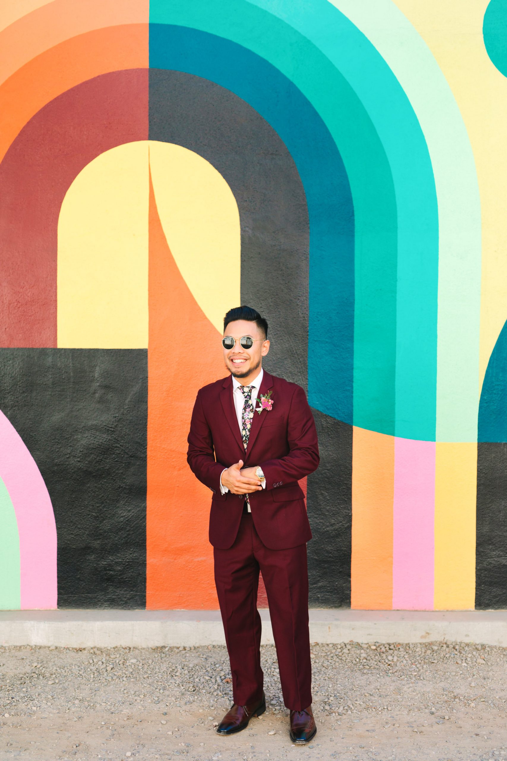Groom in burgundy suit in front of colorful Jessie and Katey mural in Sacramento - www.marycostaweddings.com