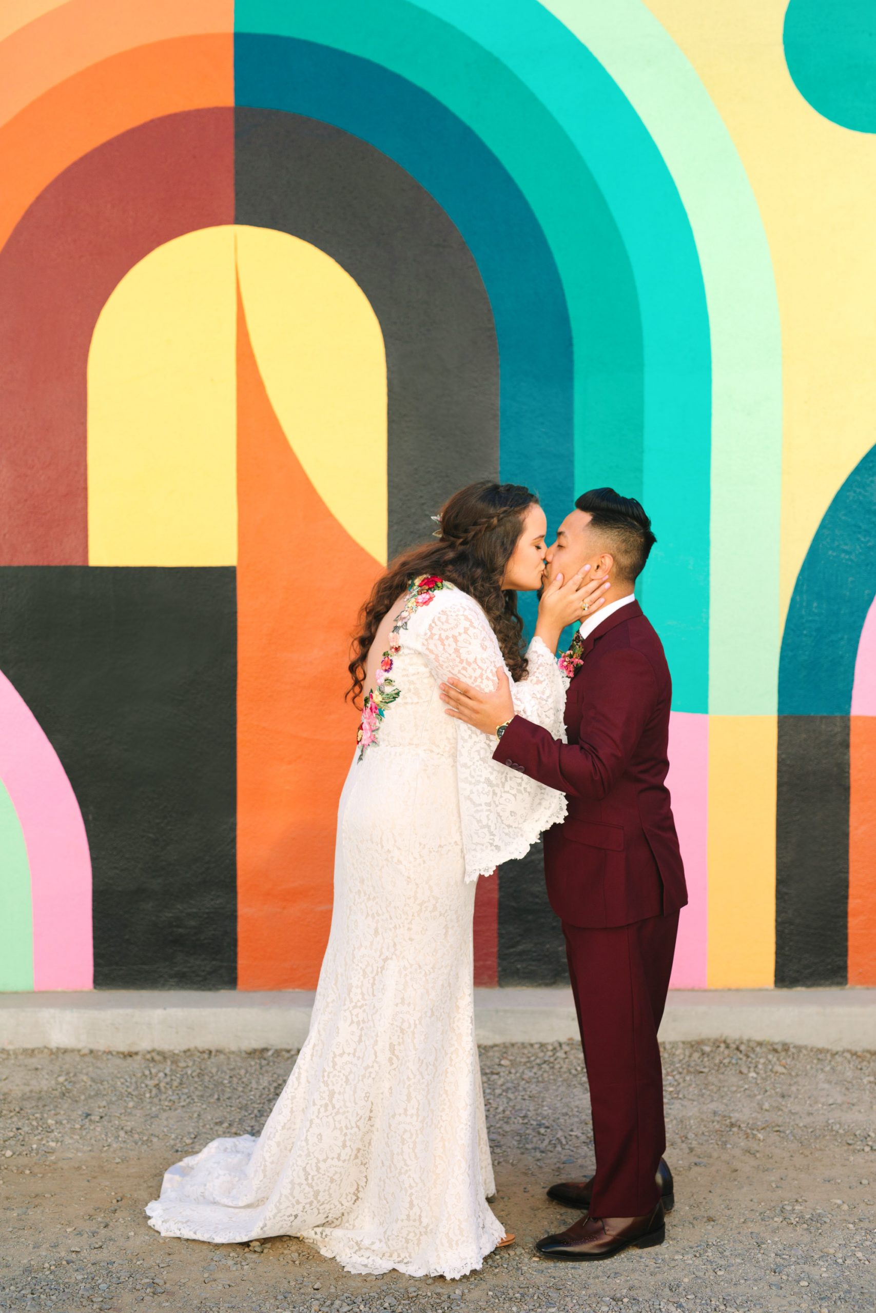 Bride and groom kissing in front of colorful Jessie and Katey mural in Sacramento - www.marycostaweddings.com