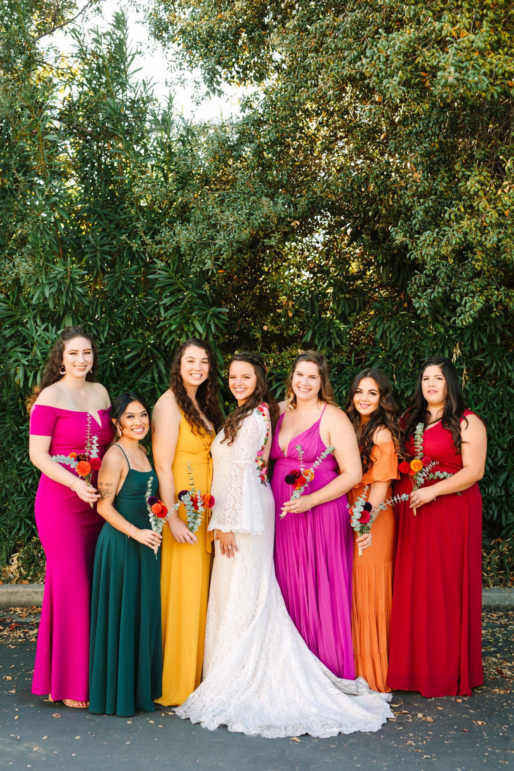 Bride and bridesmaids in colorful assorted dresses - www.marycostaweddings.com
