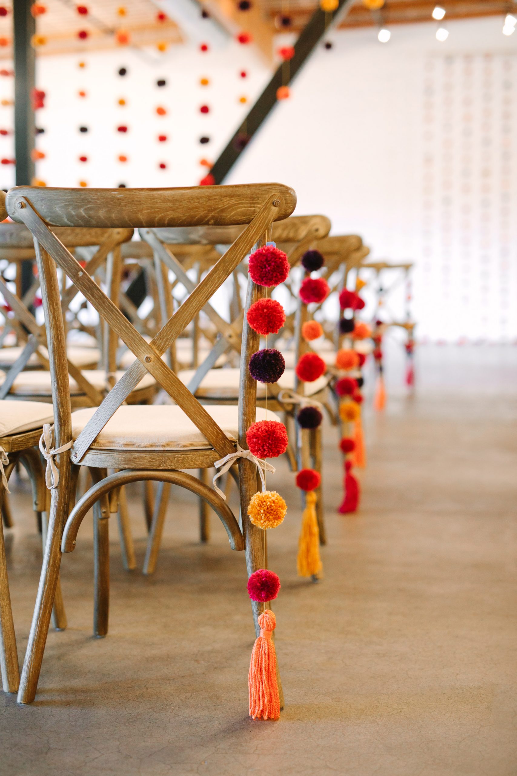 DIY pom poms on chairs for wedding ceremony at BLOC Venue Roseville - www.marycostaweddings.com