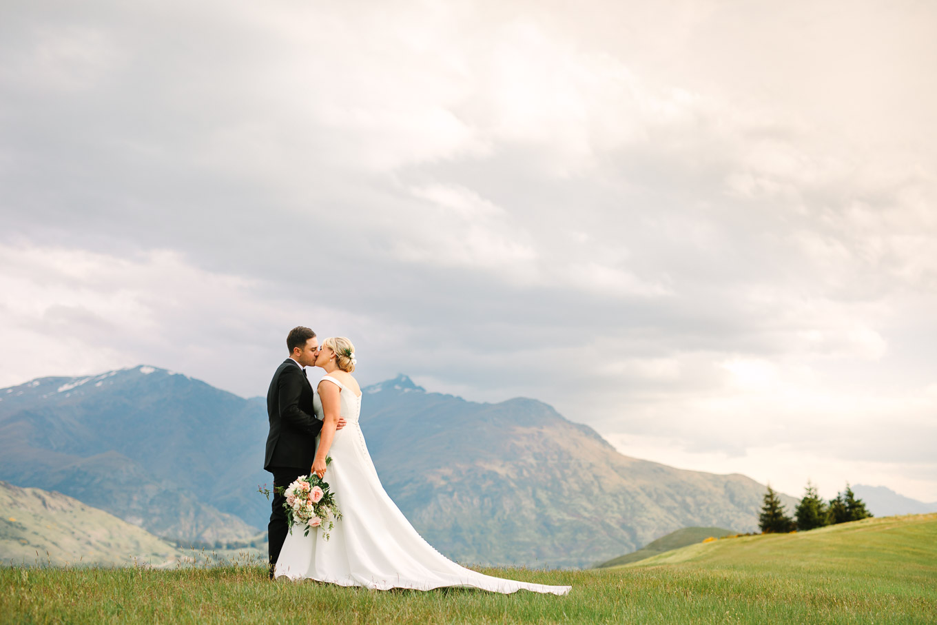 Bride and groom kissing in the New Zealand Mountains at Millbrook Resort wedding. Queenstown NZ wedding by Mary Costa Photography | www.marycostaweddings.com