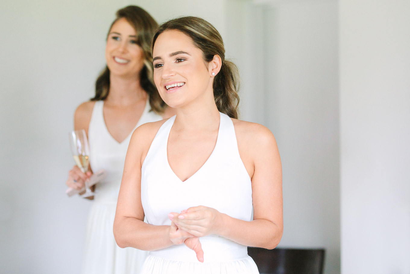 Bridesmaids in white looking on adoringly. Millbrook Resort Queenstown New Zealand wedding by Mary Costa Photography | www.marycostaweddings.com