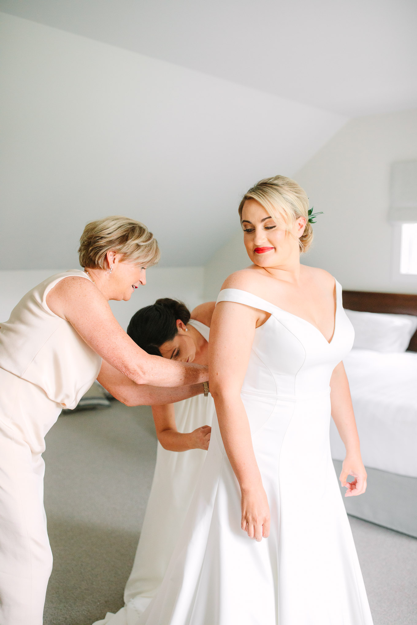 Bride getting dressed in off the shoulder gown. Millbrook Resort Queenstown New Zealand wedding by Mary Costa Photography | www.marycostaweddings.com