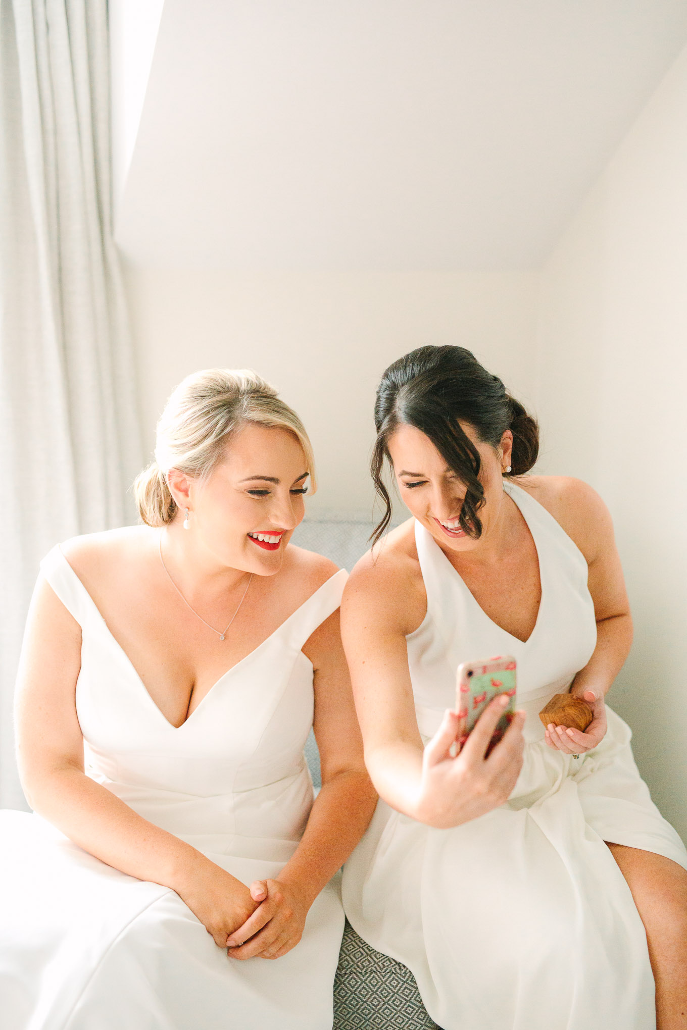 Bride and sister chatting to grandmother via Facetime on wedding day. Millbrook Resort Queenstown New Zealand wedding by Mary Costa Photography | www.marycostaweddings.com