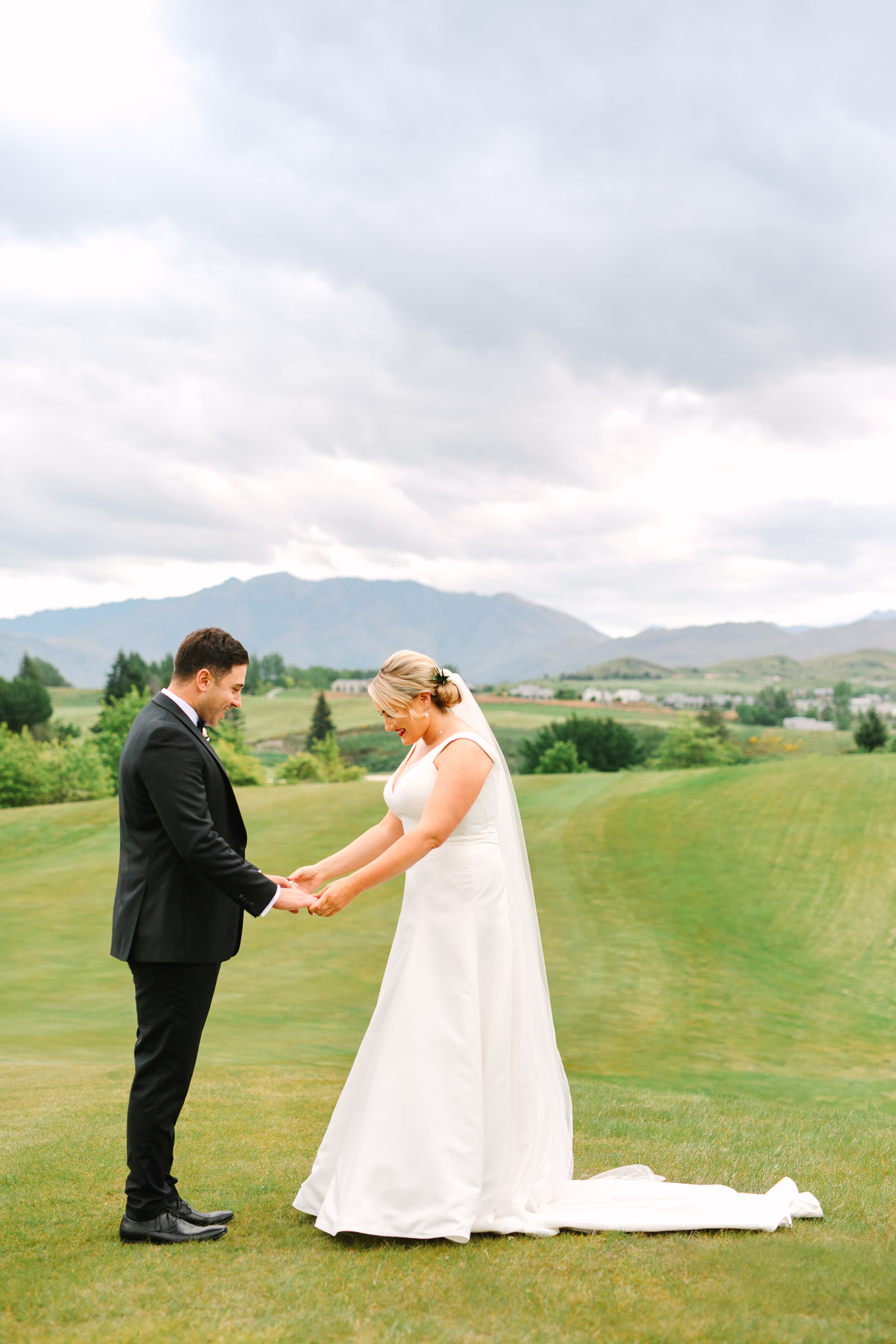 Bride and groom first look on hillside. Millbrook Resort Queenstown New Zealand wedding by Mary Costa Photography | www.marycostaweddings.com