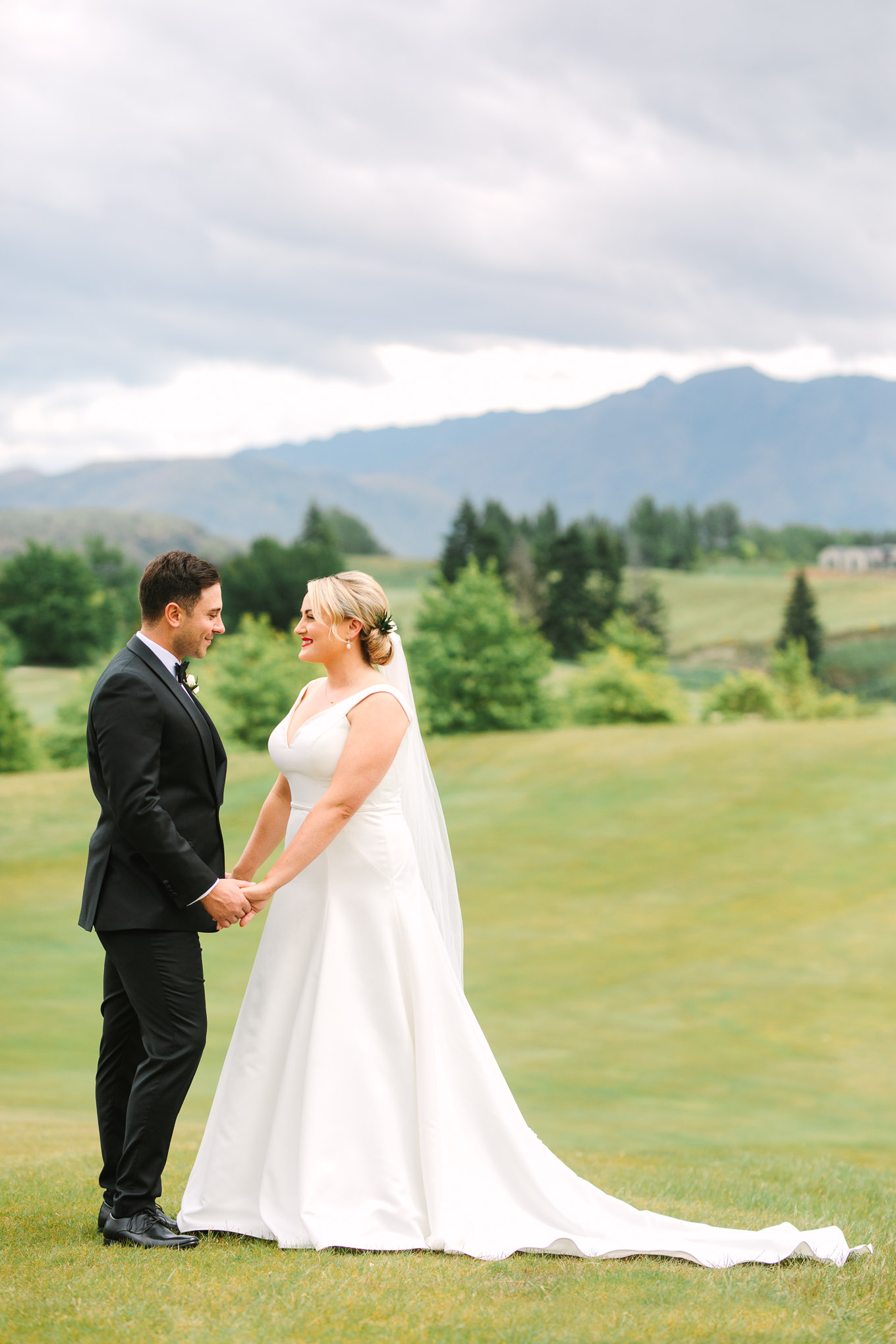 Bride and groom first look on hillside. Millbrook Resort Queenstown New Zealand wedding by Mary Costa Photography | www.marycostaweddings.com