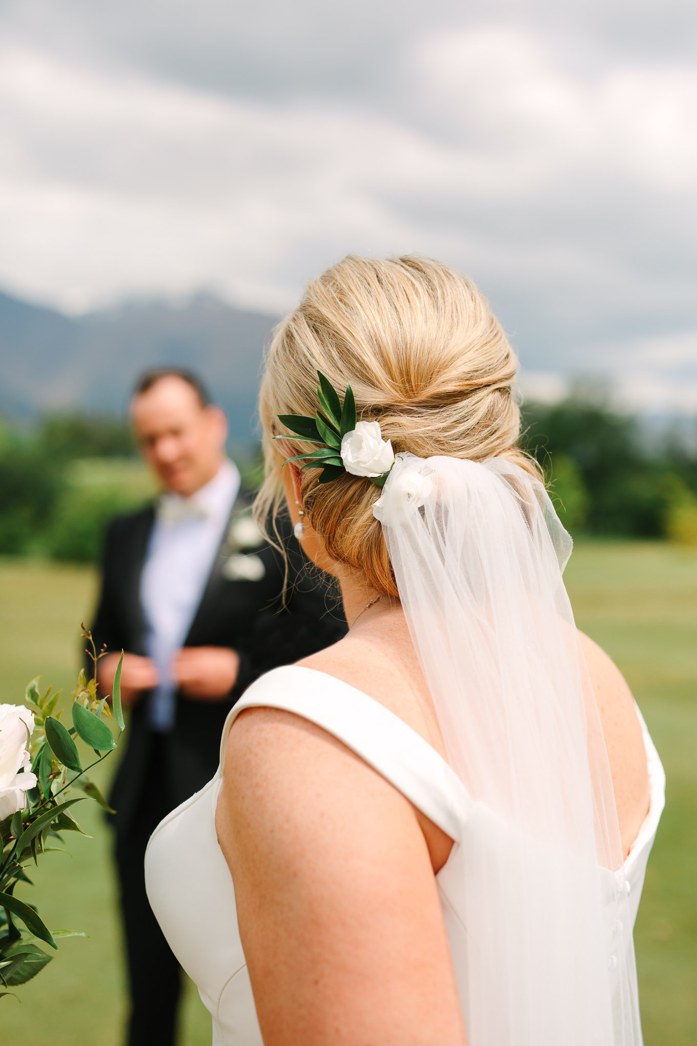 Detail of bridal updo with floral accent and veil. Millbrook Resort Queenstown New Zealand wedding by Mary Costa Photography | www.marycostaweddings.com