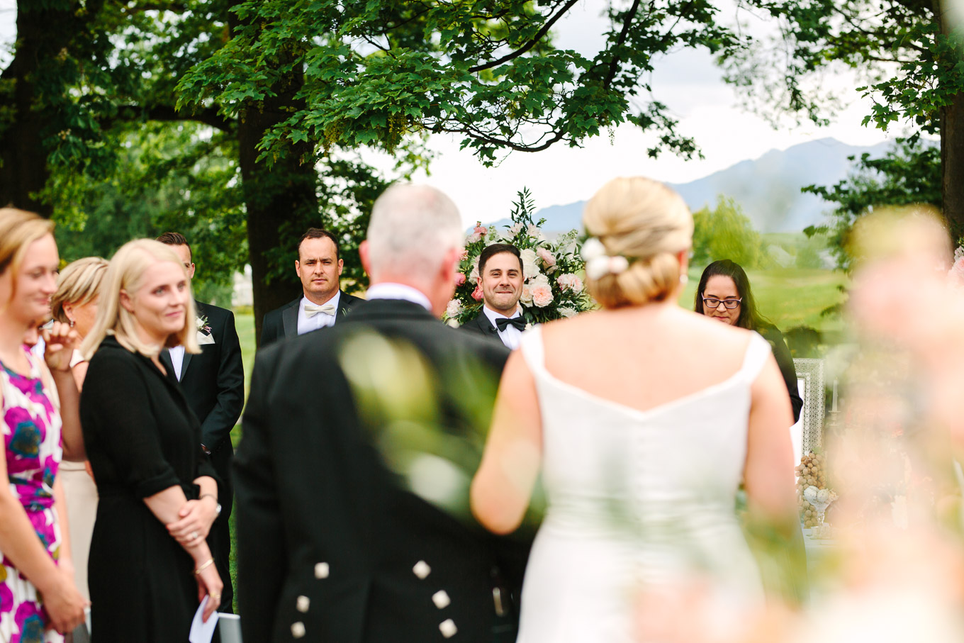 Groom seeing bride and her father walking down the aisle. Millbrook Resort Queenstown New Zealand wedding by Mary Costa Photography | www.marycostaweddings.com