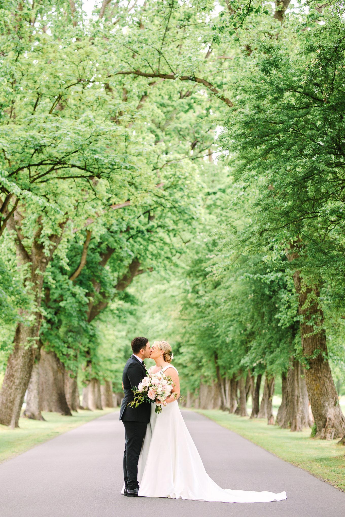 Bride and groom portrait in tree-lined road. Millbrook Resort Queenstown New Zealand wedding by Mary Costa Photography | www.marycostaweddings.com