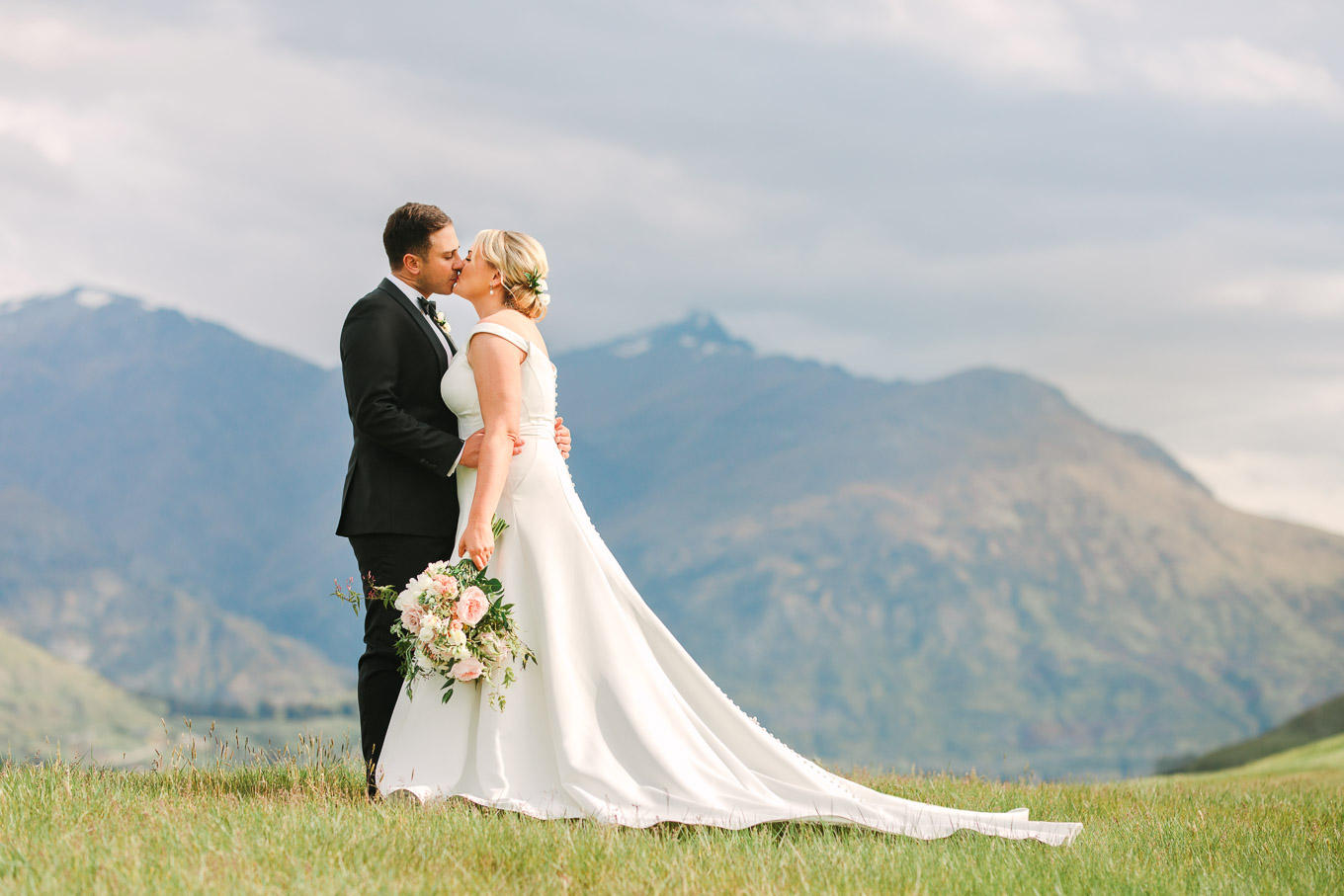 Wedding portrait on a hillside with Southern Alps in the background. Millbrook Resort Queenstown New Zealand wedding by Mary Costa Photography | www.marycostaweddings.com