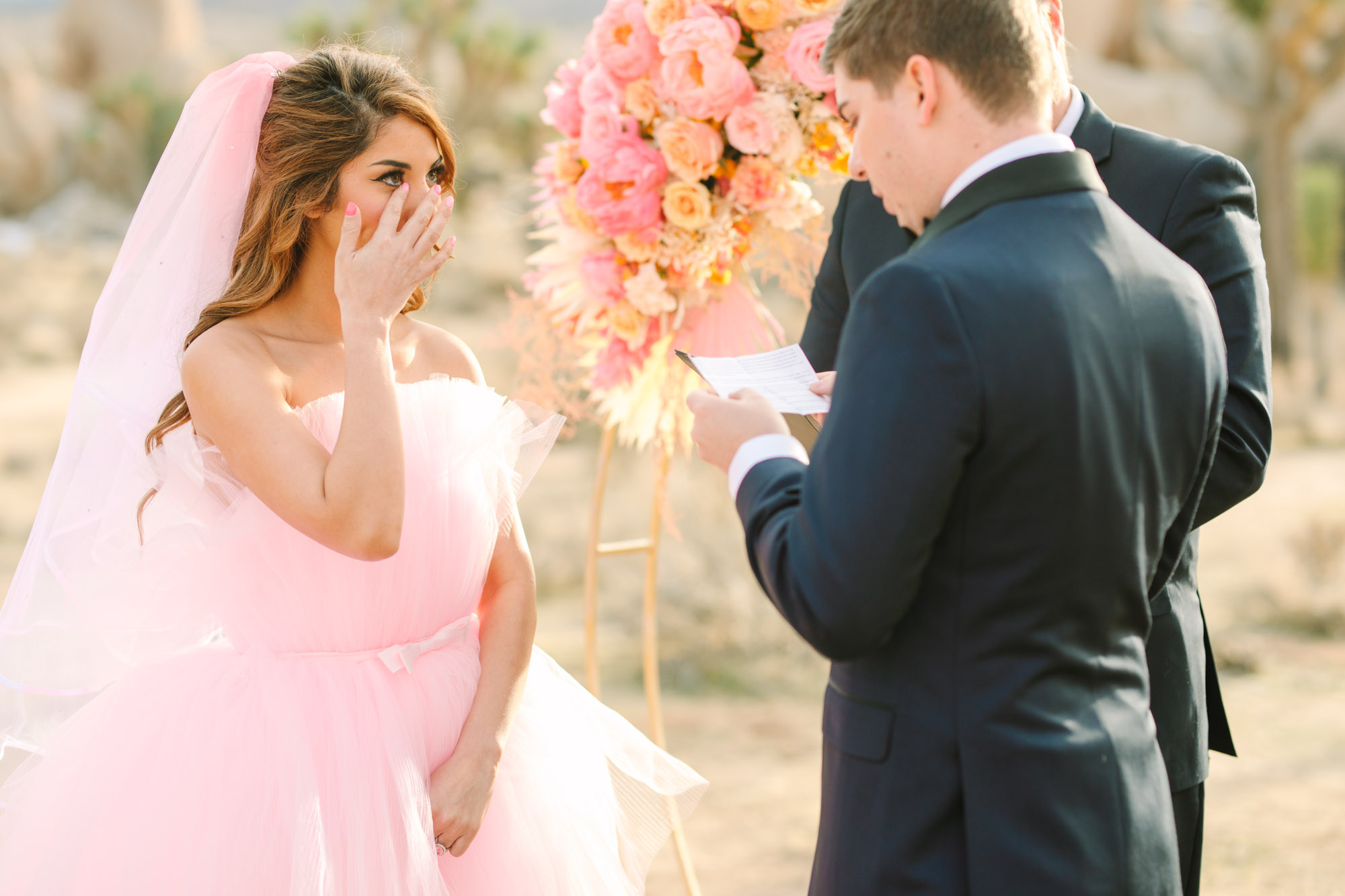 Bride wiping away tear | Pink wedding dress Joshua Tree elopement featured on Green Wedding Shoes | Colorful desert wedding inspiration for fun-loving couples in Southern California #joshuatreewedding #joshuatreeelopement #pinkwedding #greenweddingshoes Source: Mary Costa Photography | Los Angeles
