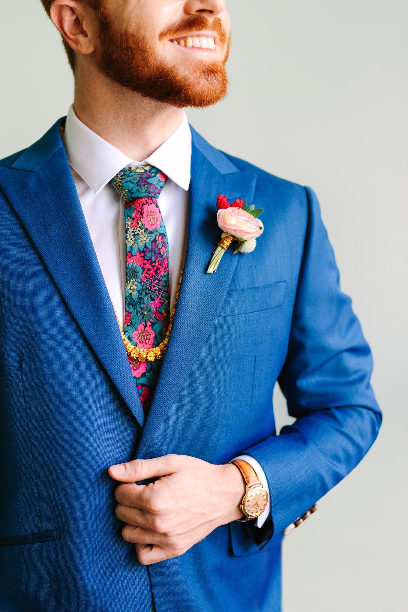 Bright blue suit jacket detail with OTAA tie and gold necklace. Two Disney artists create a unique and colorful Indian Fusion wedding at The Fig House Los Angeles, featured on Green Wedding Shoes. | Colorful and elevated wedding inspiration for fun-loving couples in Southern California | #indianwedding #indianfusionwedding #thefighouse #losangeleswedding   Source: Mary Costa Photography | Los Angeles