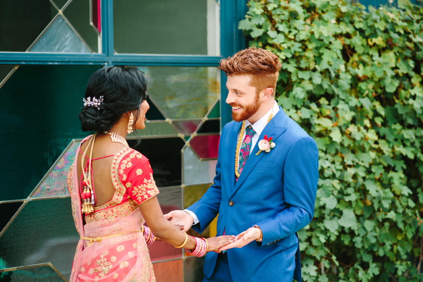First look with bride in red saree and groom in bright blue suit. Two Disney artists create a unique and colorful Indian Fusion wedding at The Fig House Los Angeles, featured on Green Wedding Shoes. | Colorful and elevated wedding inspiration for fun-loving couples in Southern California | #indianwedding #indianfusionwedding #thefighouse #losangeleswedding   Source: Mary Costa Photography | Los Angeles