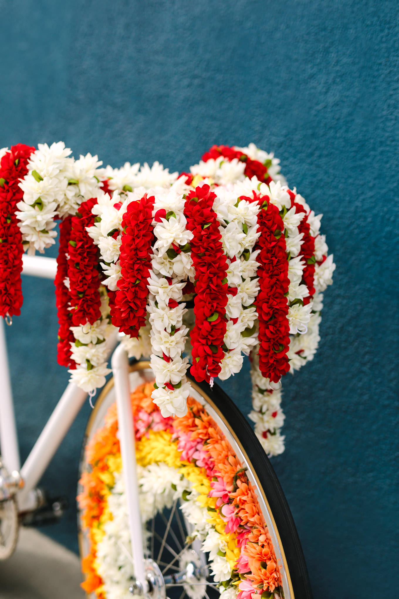 Floral Baraat bicycle on teal wall. Two Disney artists create a unique and colorful Indian Fusion wedding at The Fig House Los Angeles, featured on Green Wedding Shoes. | Colorful and elevated wedding inspiration for fun-loving couples in Southern California | #indianwedding #indianfusionwedding #thefighouse #losangeleswedding   Source: Mary Costa Photography | Los Angeles