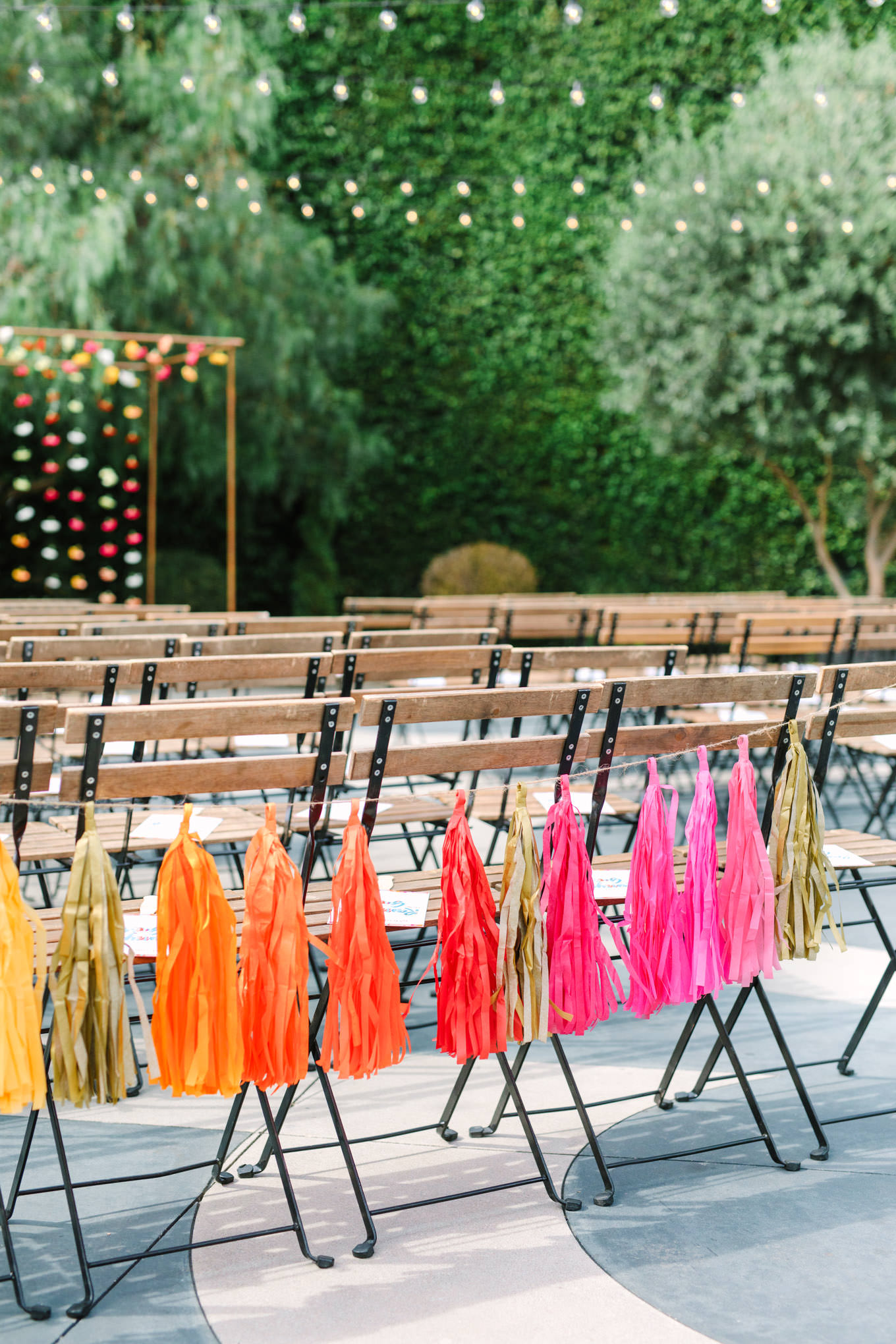 Outdoor ceremony with colorful paper tassels. Two Disney artists create a unique and colorful Indian Fusion wedding at The Fig House Los Angeles, featured on Green Wedding Shoes. | Colorful and elevated wedding inspiration for fun-loving couples in Southern California | #indianwedding #indianfusionwedding #thefighouse #losangeleswedding   Source: Mary Costa Photography | Los Angeles