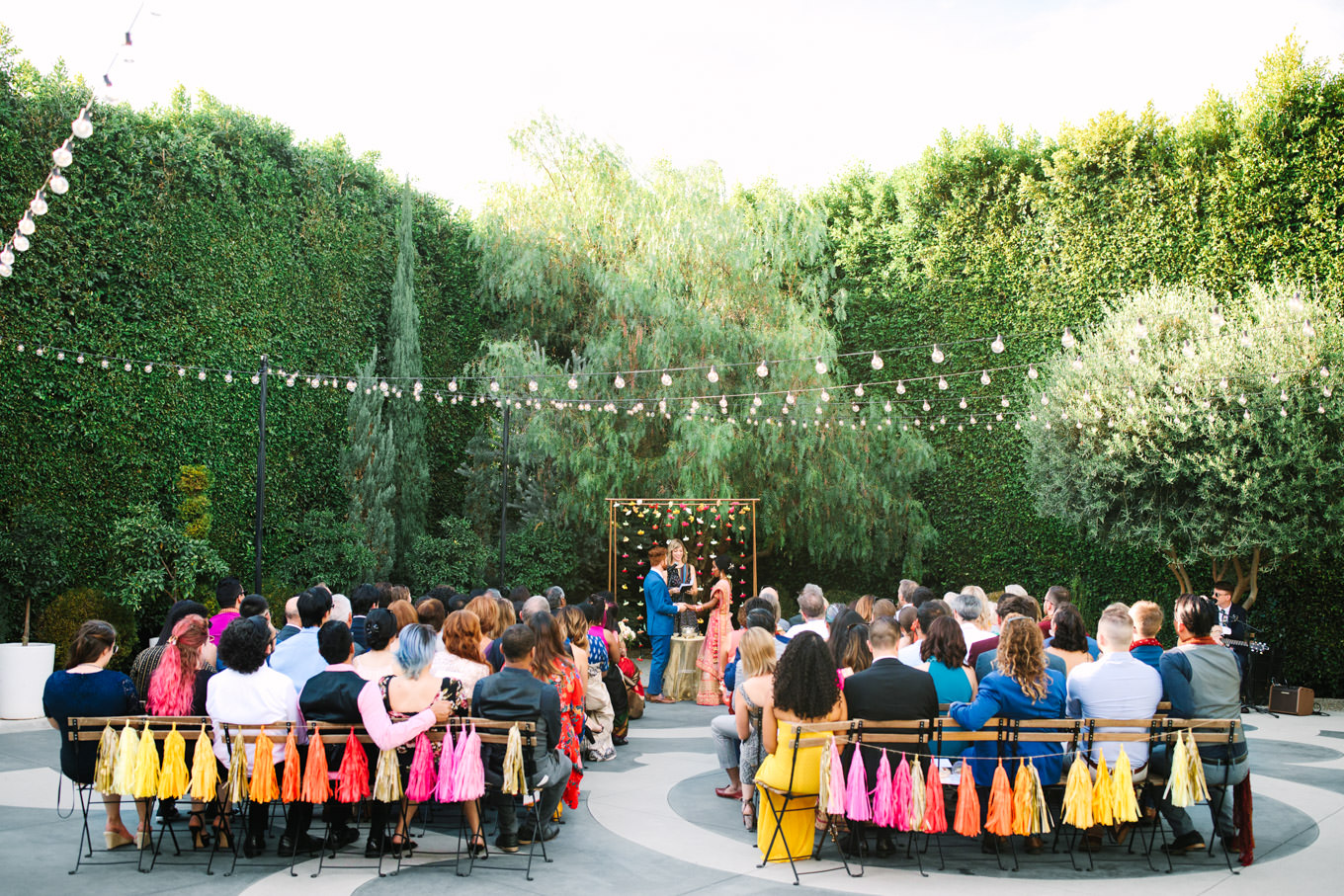 Wide shot of wedding ceremony. Two Disney artists create a unique and colorful Indian Fusion wedding at The Fig House Los Angeles, featured on Green Wedding Shoes. | Colorful and elevated wedding inspiration for fun-loving couples in Southern California | #indianwedding #indianfusionwedding #thefighouse #losangeleswedding   Source: Mary Costa Photography | Los Angeles