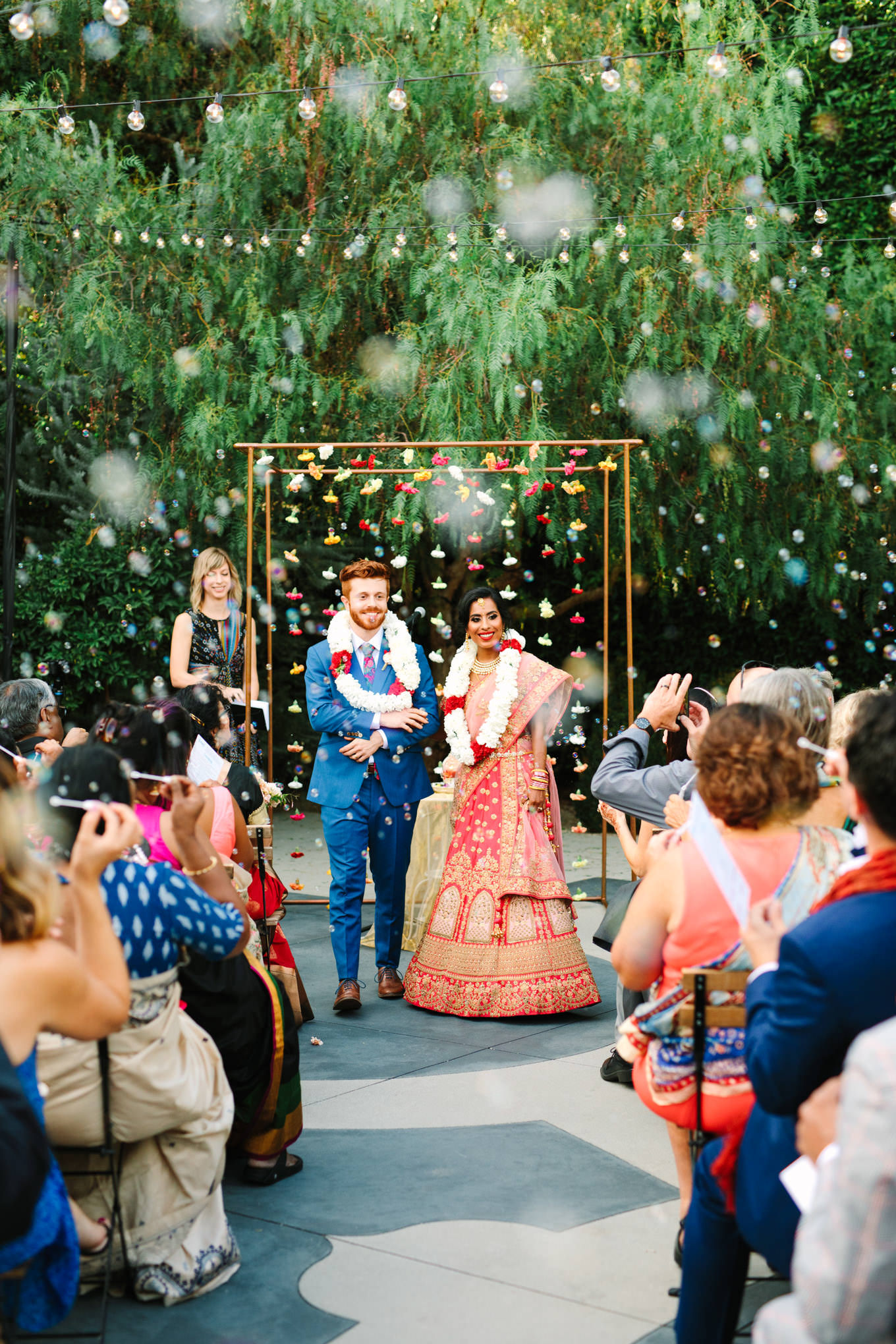 Wedding ceremony processional with bubbles. Two Disney artists create a unique and colorful Indian Fusion wedding at The Fig House Los Angeles, featured on Green Wedding Shoes. | Colorful and elevated wedding inspiration for fun-loving couples in Southern California | #indianwedding #indianfusionwedding #thefighouse #losangeleswedding   Source: Mary Costa Photography | Los Angeles