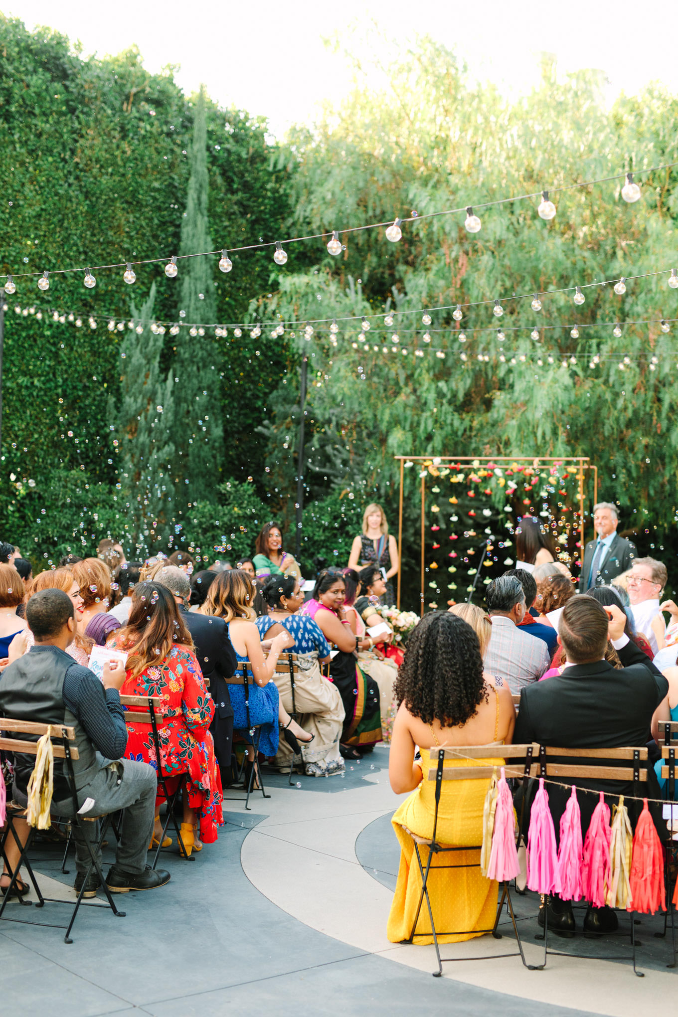 Wedding ceremony guests. Two Disney artists create a unique and colorful Indian Fusion wedding at The Fig House Los Angeles, featured on Green Wedding Shoes. | Colorful and elevated wedding inspiration for fun-loving couples in Southern California | #indianwedding #indianfusionwedding #thefighouse #losangeleswedding   Source: Mary Costa Photography | Los Angeles