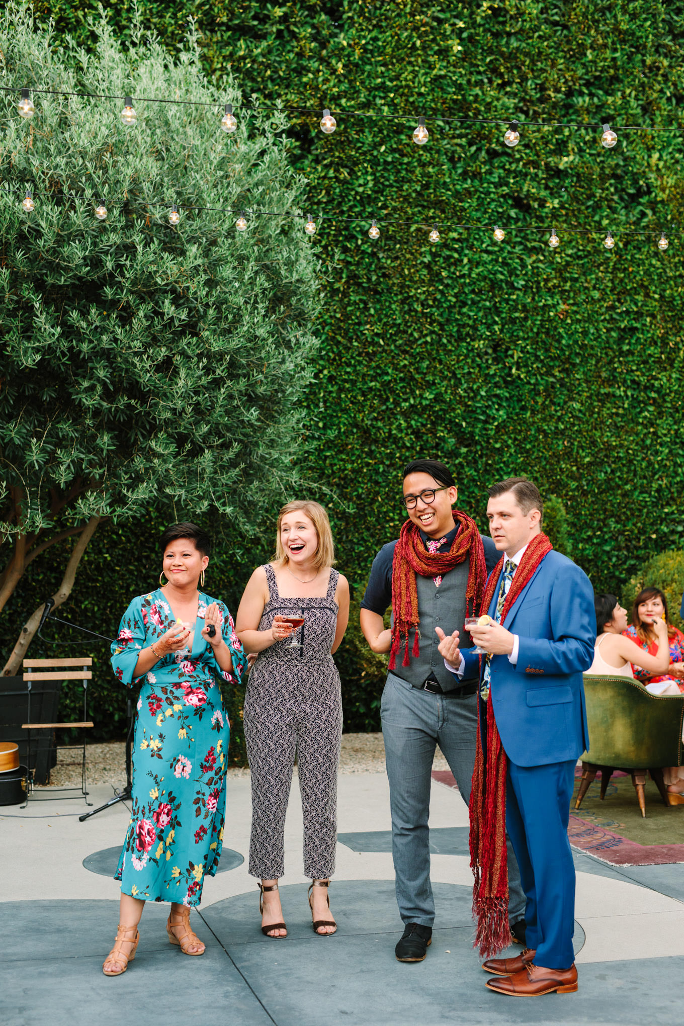 Wedding guests laughing during cocktail hour. Two Disney artists create a unique and colorful Indian Fusion wedding at The Fig House Los Angeles, featured on Green Wedding Shoes. | Colorful and elevated wedding inspiration for fun-loving couples in Southern California | #indianwedding #indianfusionwedding #thefighouse #losangeleswedding   Source: Mary Costa Photography | Los Angeles