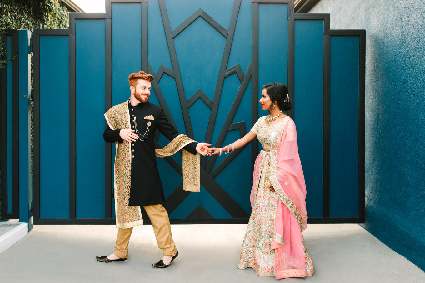 Bride and groom in front of geometric bold door. Two Disney artists create a unique and colorful Indian Fusion wedding at The Fig House Los Angeles, featured on Green Wedding Shoes. | Colorful and elevated wedding inspiration for fun-loving couples in Southern California | #indianwedding #indianfusionwedding #thefighouse #losangeleswedding   Source: Mary Costa Photography | Los Angeles