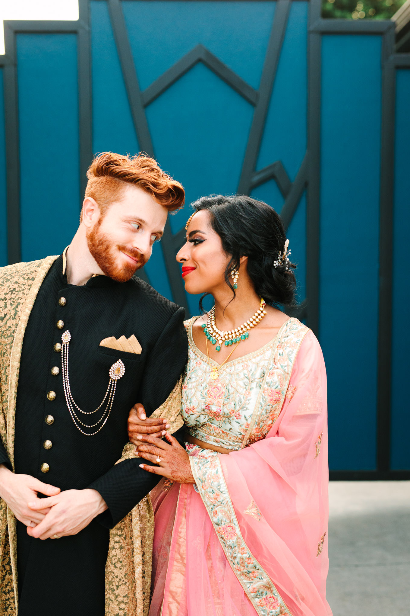 Bride and groom in front of geometric bold door. Two Disney artists create a unique and colorful Indian Fusion wedding at The Fig House Los Angeles, featured on Green Wedding Shoes. | Colorful and elevated wedding inspiration for fun-loving couples in Southern California | #indianwedding #indianfusionwedding #thefighouse #losangeleswedding   Source: Mary Costa Photography | Los Angeles