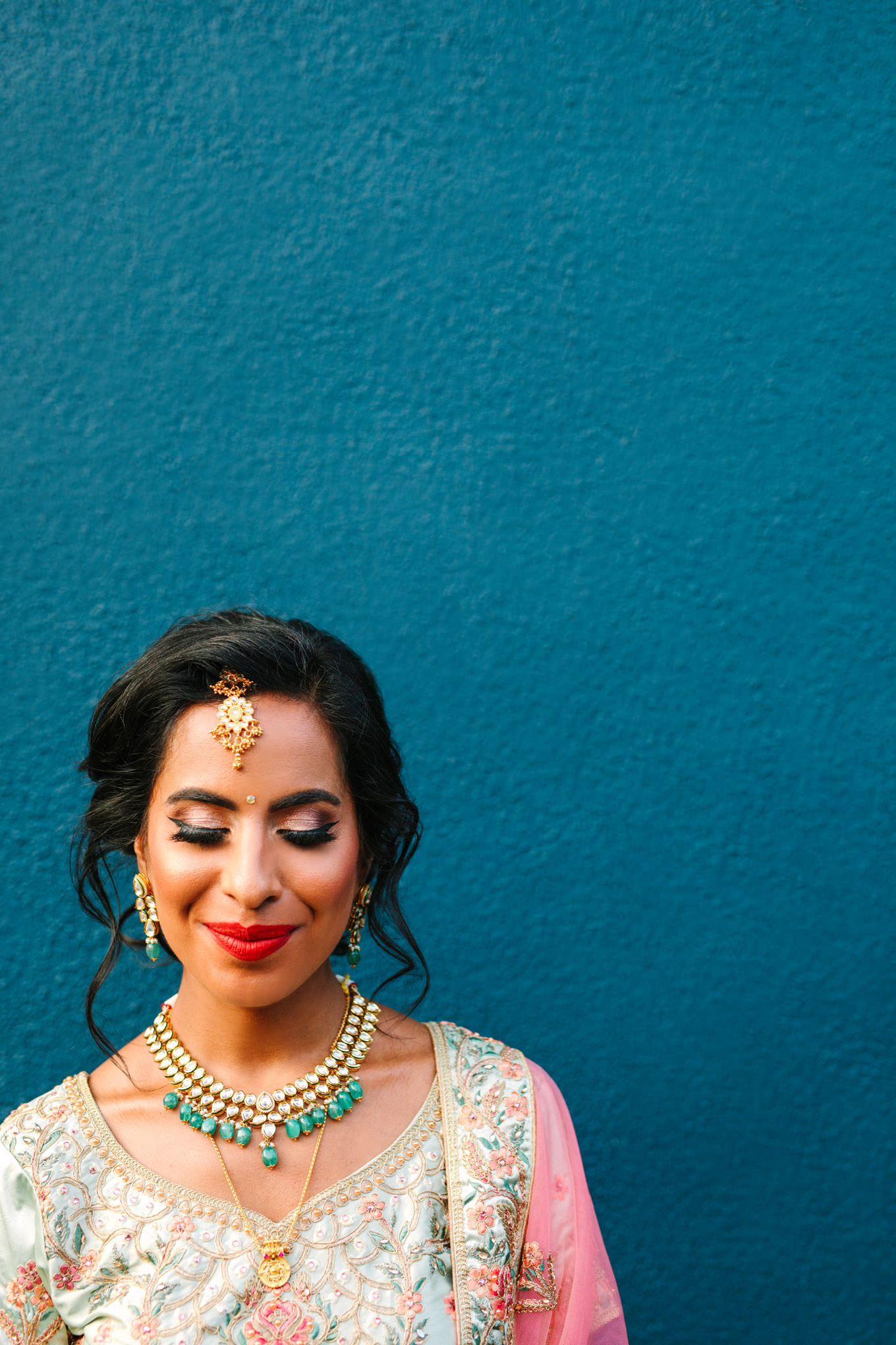 Bride in pink, cream, and emerald embroidered gown. Bride in saree with cocktail in front of teal wall. Two Disney artists create a unique and colorful Indian Fusion wedding at The Fig House Los Angeles, featured on Green Wedding Shoes. | Colorful and elevated wedding inspiration for fun-loving couples in Southern California | #indianwedding #indianfusionwedding #thefighouse #losangeleswedding   Source: Mary Costa Photography | Los Angeles