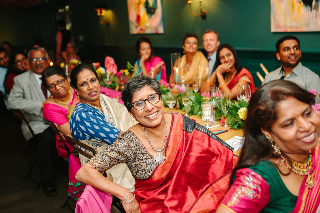 Wedding guests listening to speeches. Two Disney artists create a unique and colorful Indian Fusion wedding at The Fig House Los Angeles, featured on Green Wedding Shoes. | Colorful and elevated wedding inspiration for fun-loving couples in Southern California | #indianwedding #indianfusionwedding #thefighouse #losangeleswedding   Source: Mary Costa Photography | Los Angeles