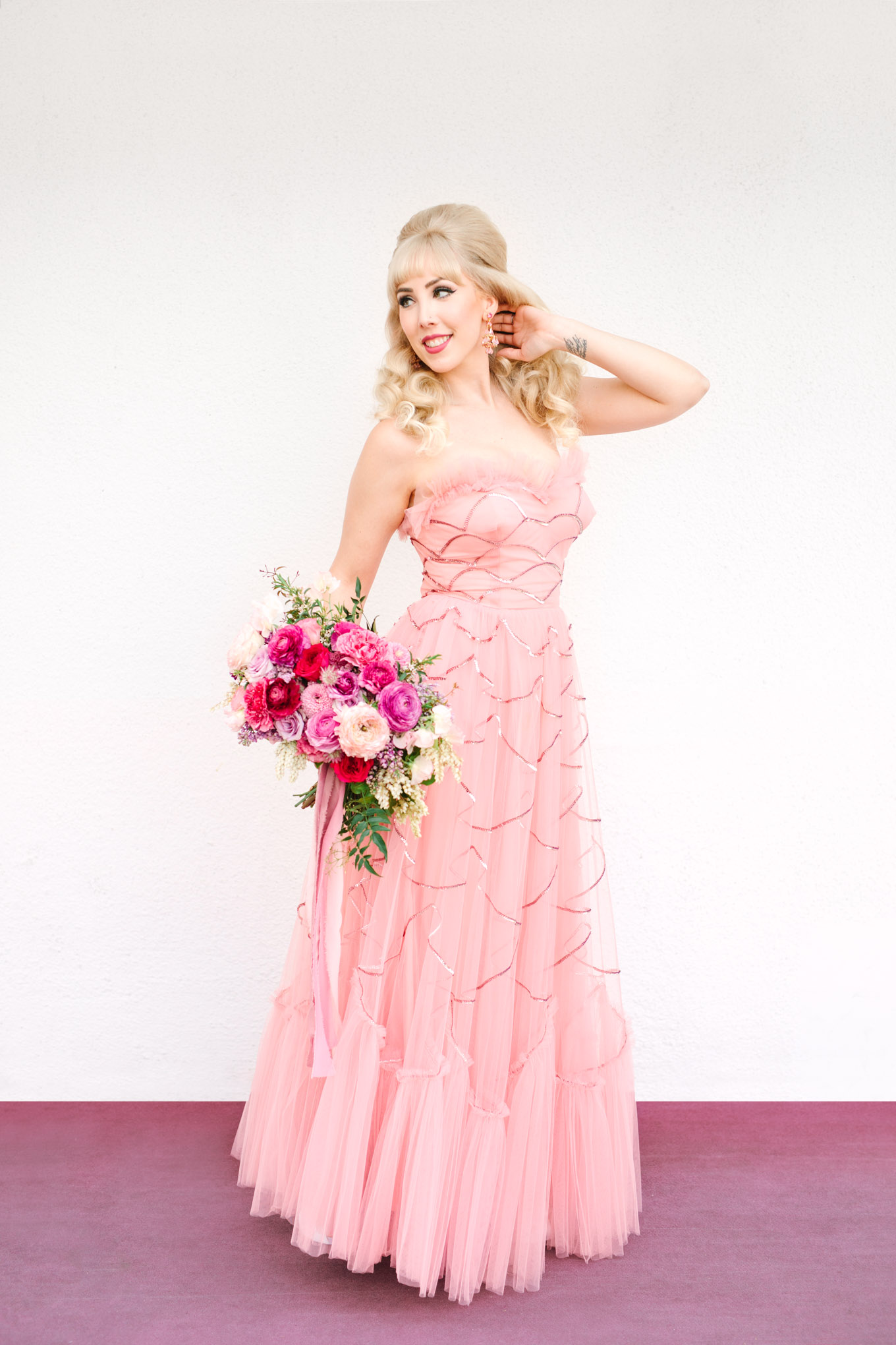 Retro bride in vintage pink prom dress. Modern vintage-inspired Palm Springs engagement session with a 1960s pink Cadillac, retro clothing, and flowers by Shindig Chic. | Colorful and elevated wedding inspiration for fun-loving couples in Southern California | #engagementsession #PalmSpringsengagement #vintageweddingdress #floralcar #pinkcar   Source: Mary Costa Photography | Los Angeles