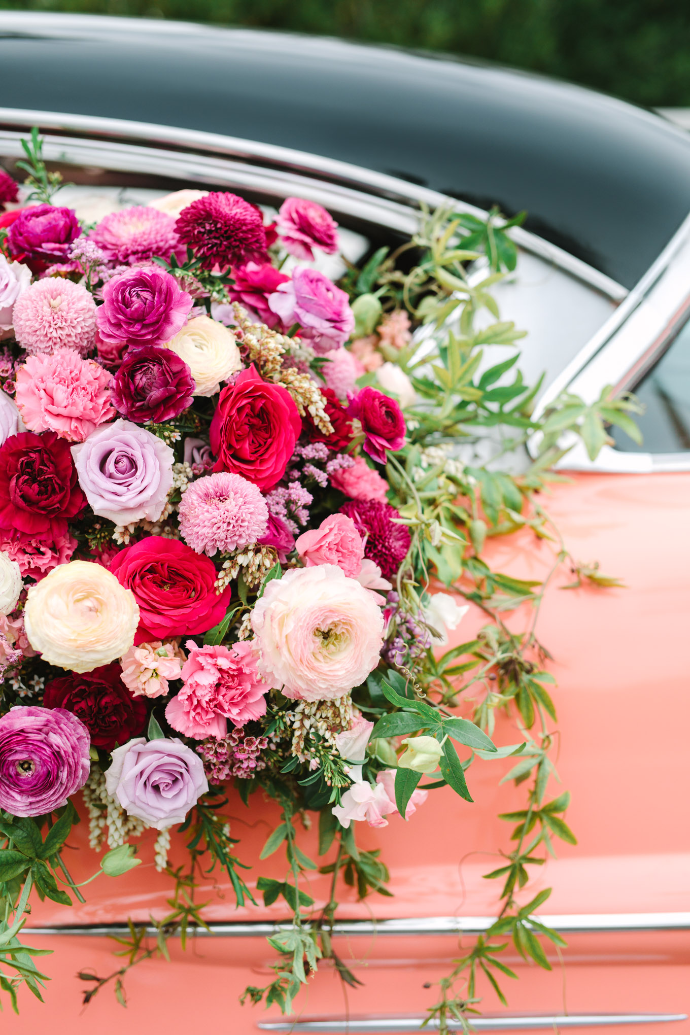Close up of flower car detail. Modern vintage-inspired Palm Springs engagement session with a 1960s pink Cadillac, retro clothing, and flowers by Shindig Chic. | Colorful and elevated wedding inspiration for fun-loving couples in Southern California | #engagementsession #PalmSpringsengagement #vintageweddingdress #floralcar #pinkcar   Source: Mary Costa Photography | Los Angeles