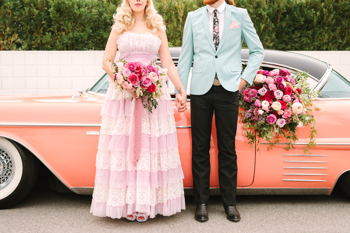 Modern vintage-inspired Palm Springs engagement session with a 1960s pink Cadillac, retro clothing, and flowers by Shindig Chic. | Colorful and elevated wedding inspiration for fun-loving couples in Southern California | #engagementsession #PalmSpringsengagement #vintageweddingdress #floralcar #pinkcar   Source: Mary Costa Photography | Los Angeles